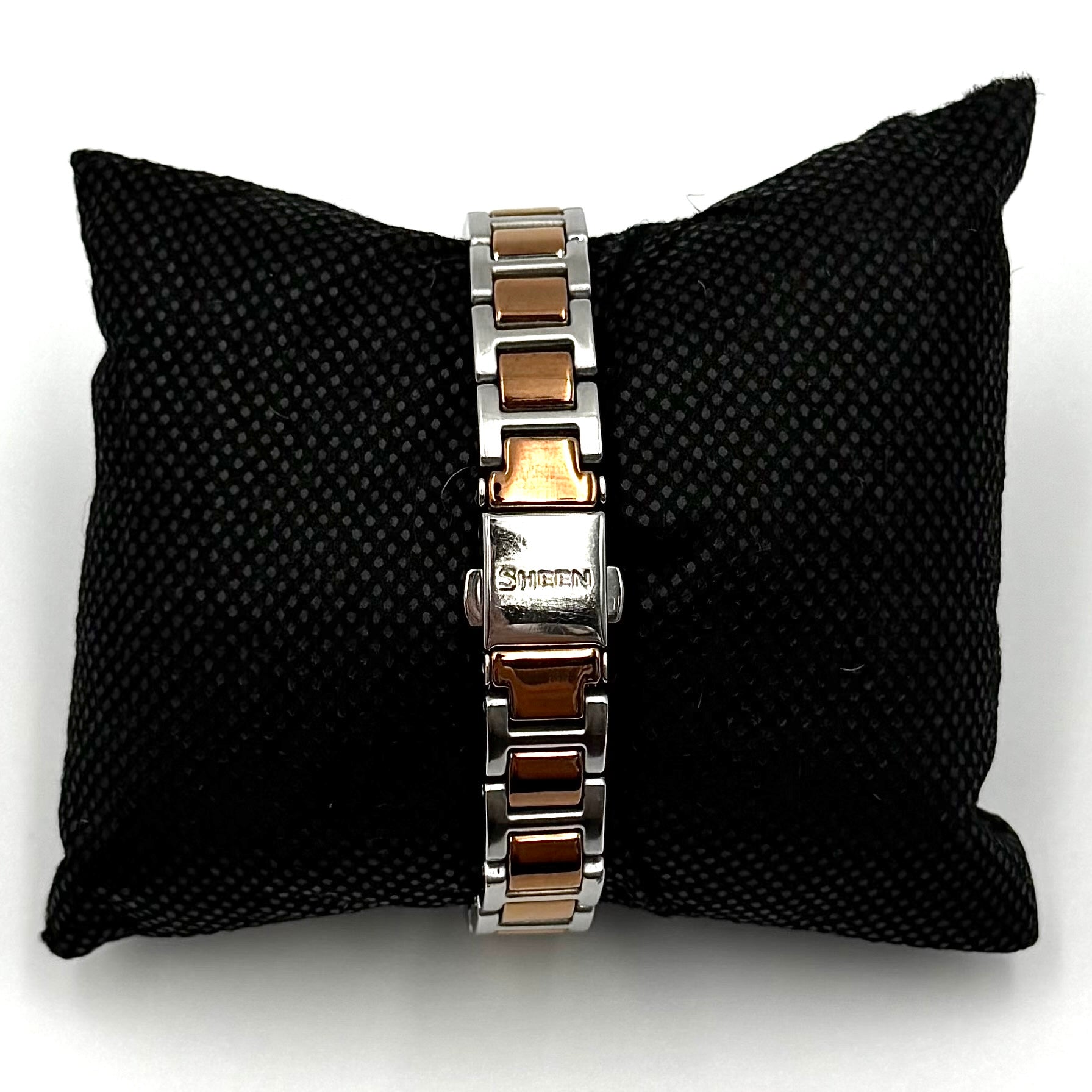 Casio Sheen SHE-4516 stainless steel watch with a rose gold and silver bracelet displayed on a black cushion.