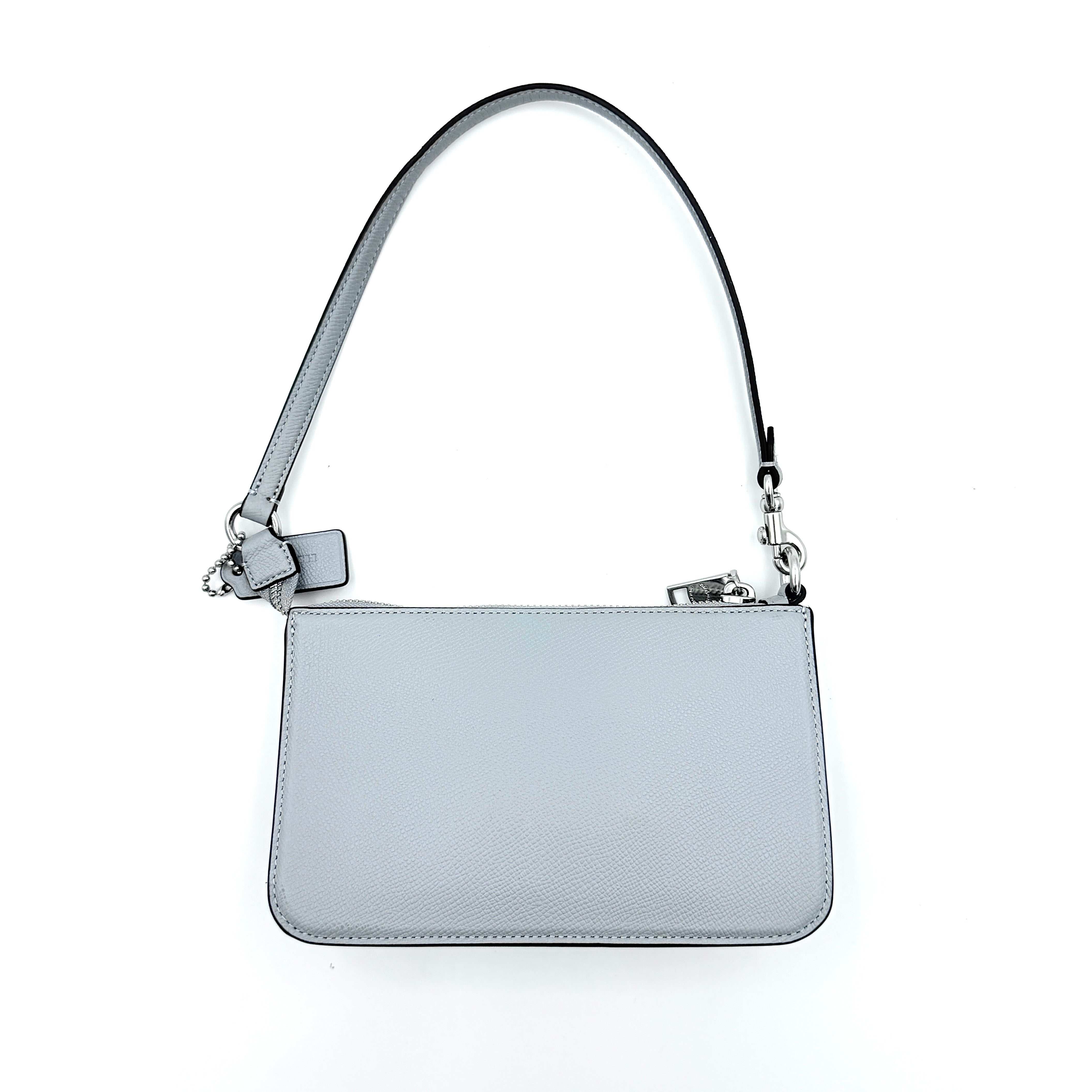 Sky blue Coach grained leather shoulder bag with silver-tone C plaque and short strap, displayed against a white background.
