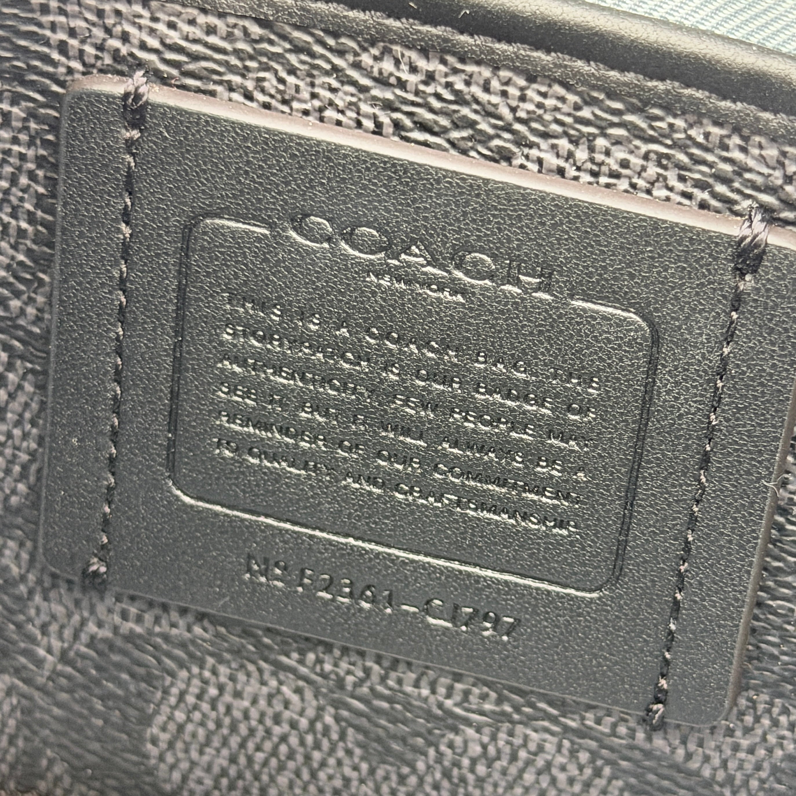 Sky blue Coach grained leather shoulder bag with silver-tone C plaque and short strap, displayed against a white background.