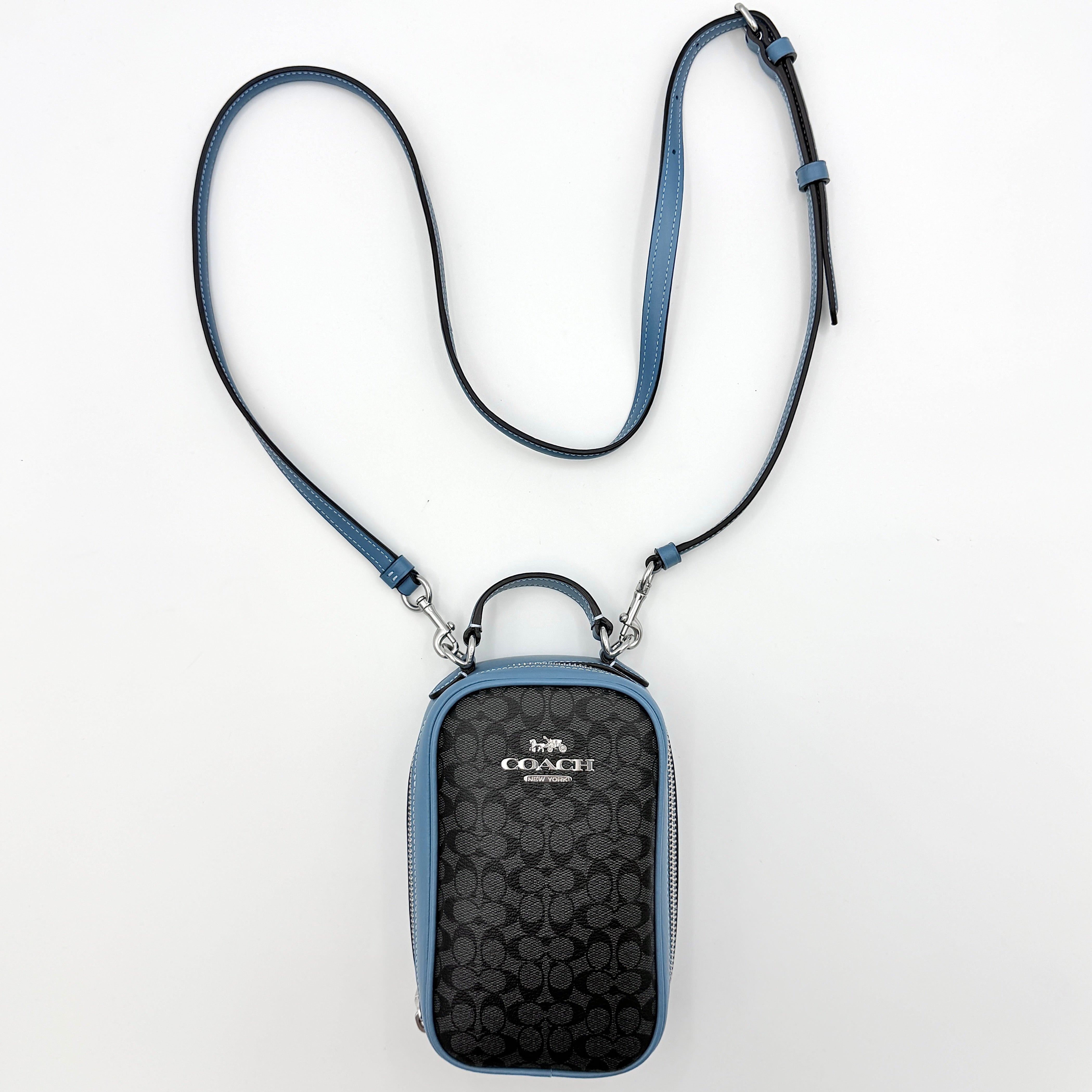 Coach Signature Eva Phone Crossbody in black coated canvas with blue leather trim and silver hardware displayed with its crossbody strap.