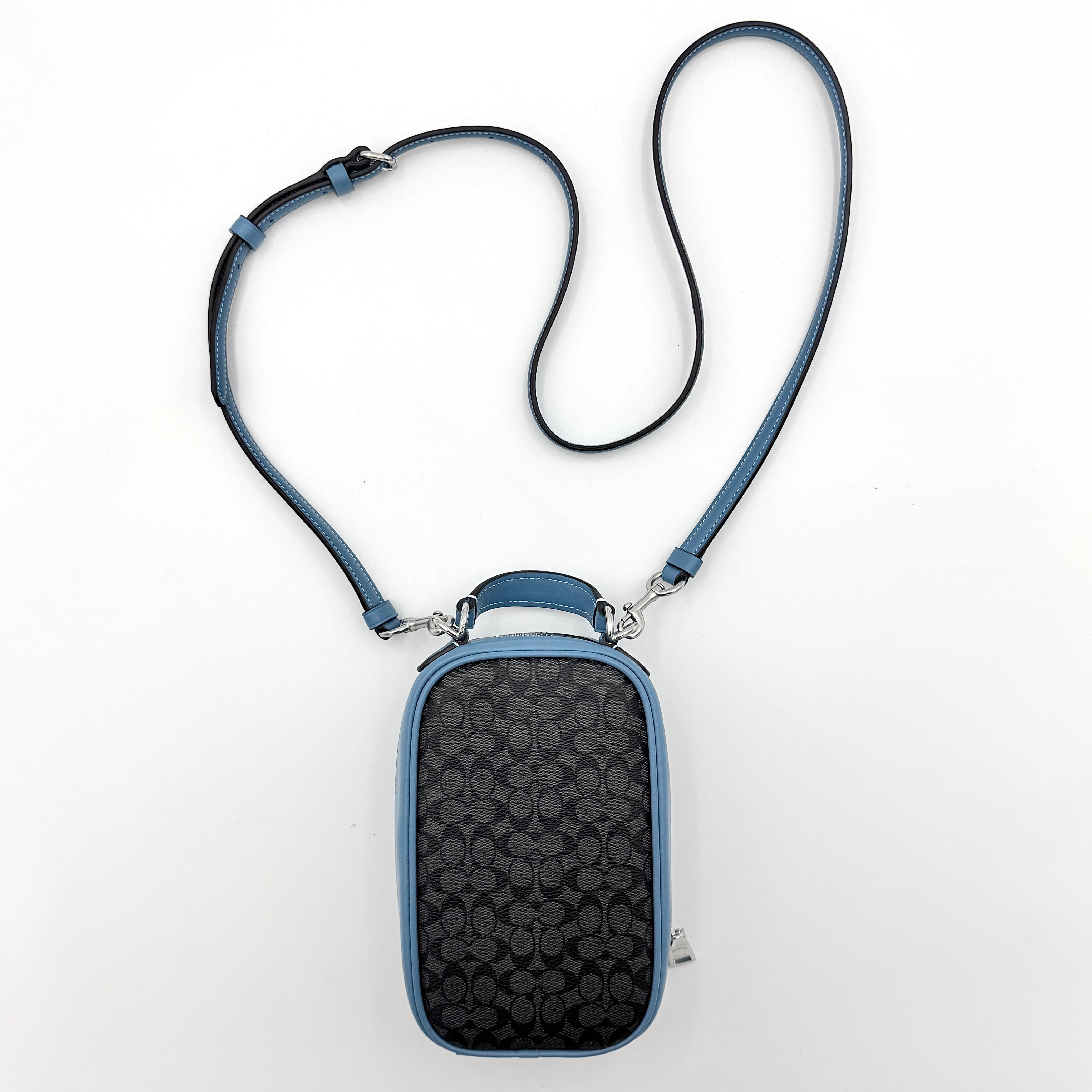 Coach Signature Eva Phone Crossbody in black coated canvas with blue leather trim and silver hardware displayed with its crossbody strap.