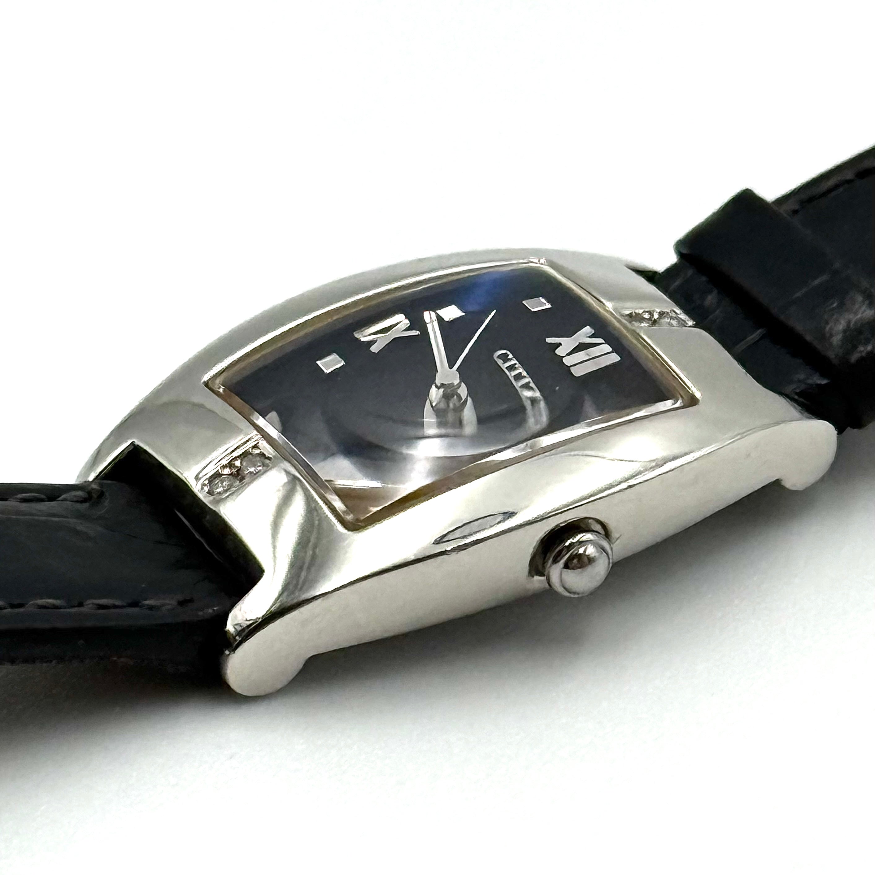Citizen Exceed watch featuring a dark blue dial, tonneau-shaped stainless steel case, and black leather strap displayed on a black cushion.