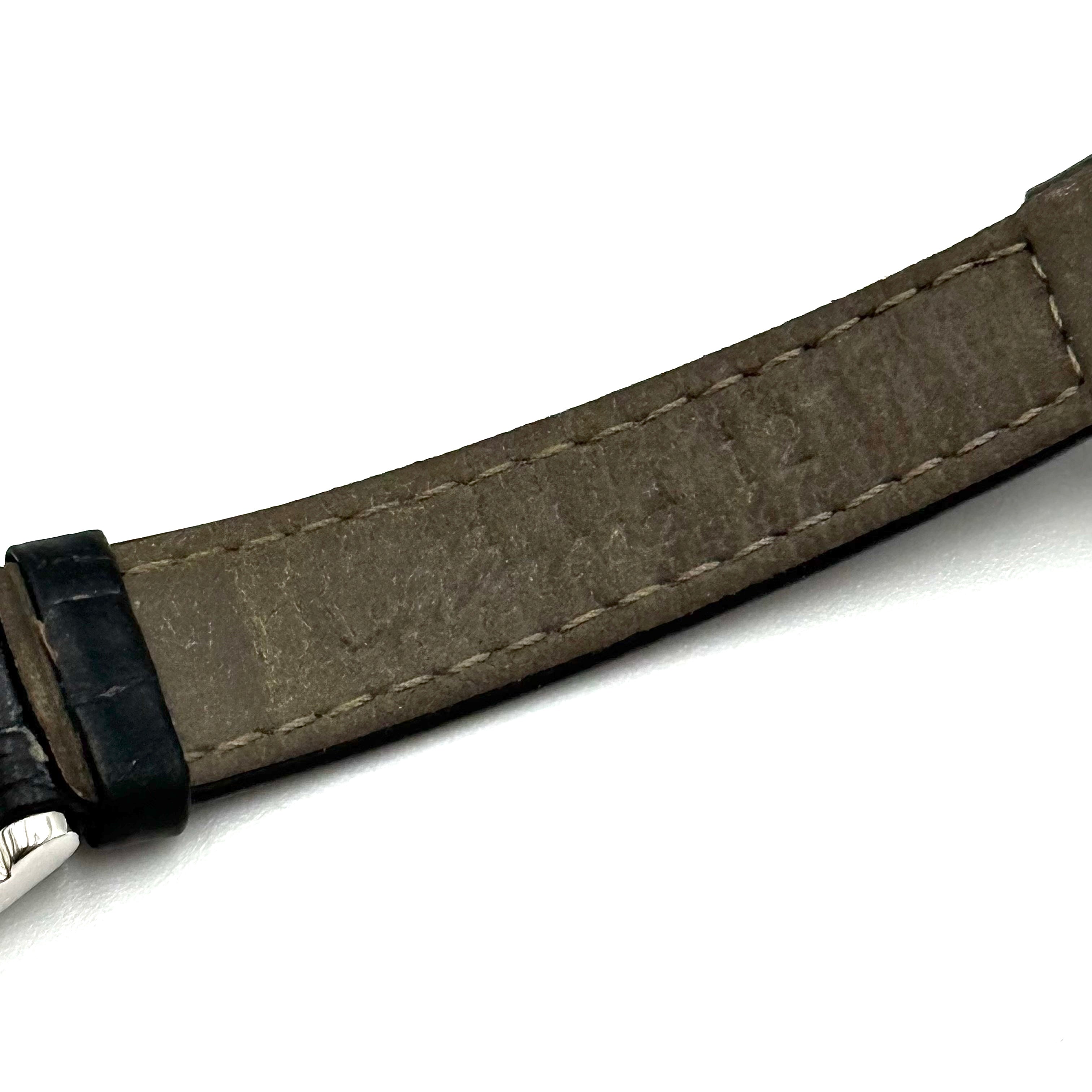 Citizen Exceed watch featuring a dark blue dial, tonneau-shaped stainless steel case, and black leather strap displayed on a black cushion.