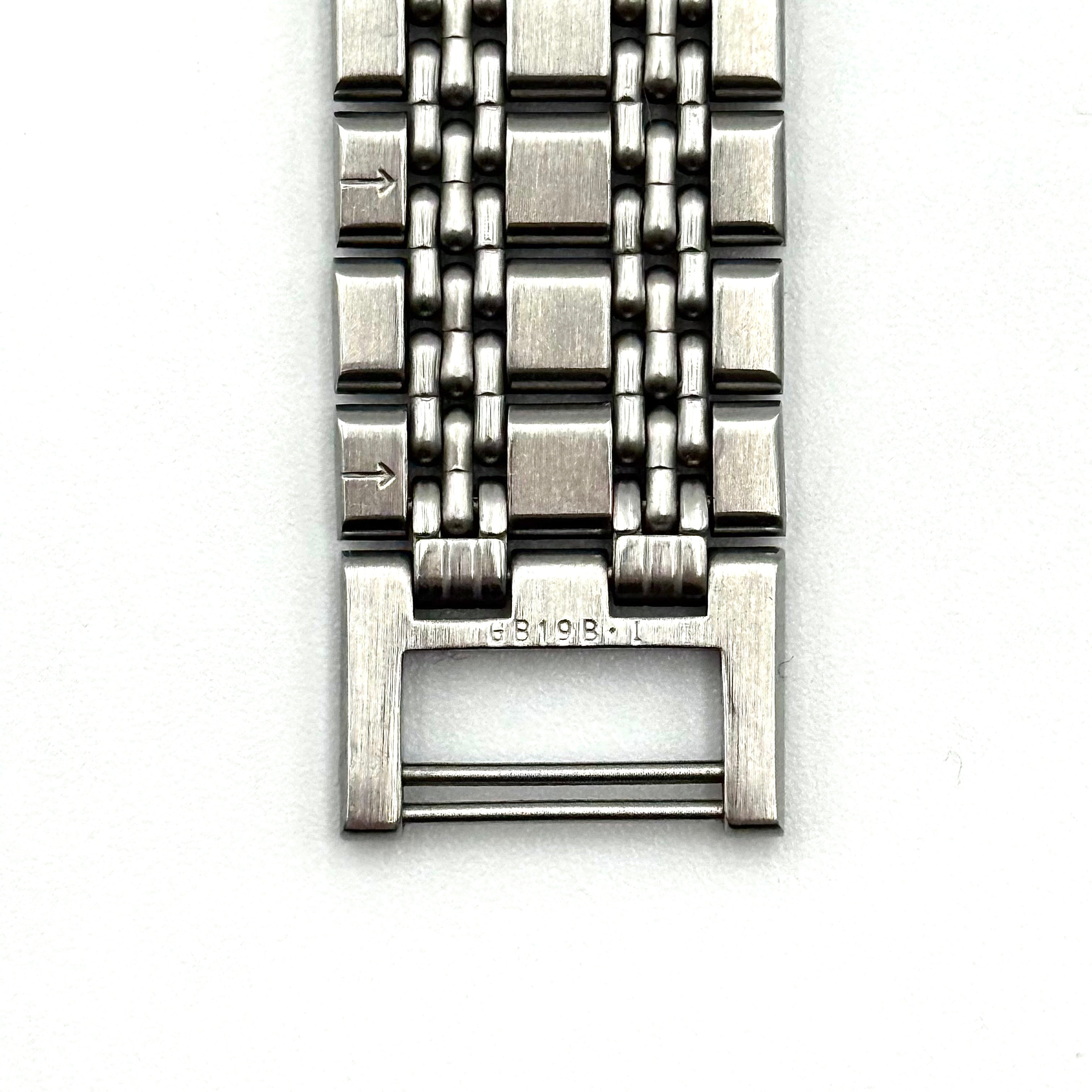 Seiko Dolce 5E31-6B90 watch in stainless steel with gold-tone accents and a cream dial, displayed on a black cushion.