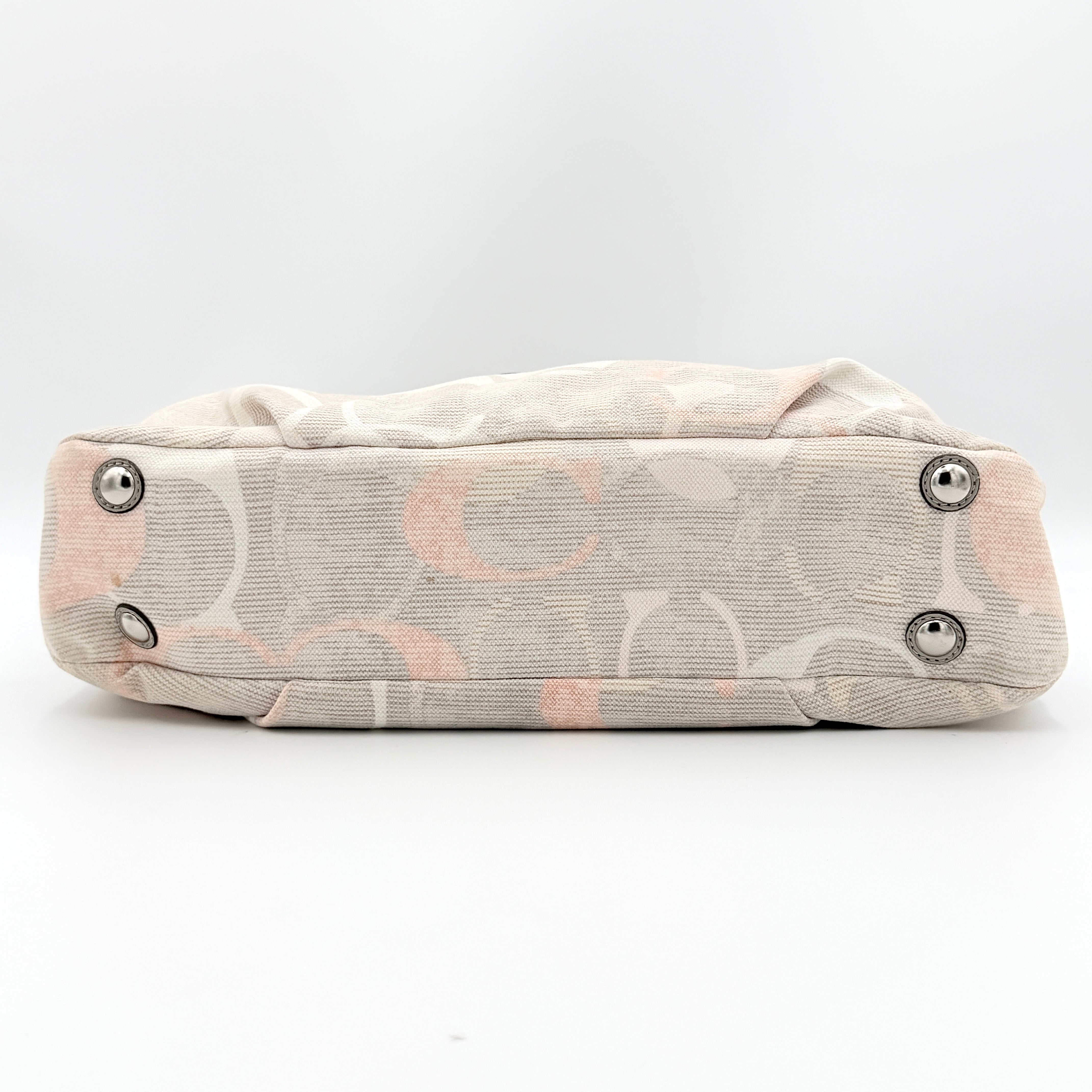 Coach Signature Optic Soho Shoulder Bag in grey and pink canvas with leather handles and buckle detail, shown against a white background.