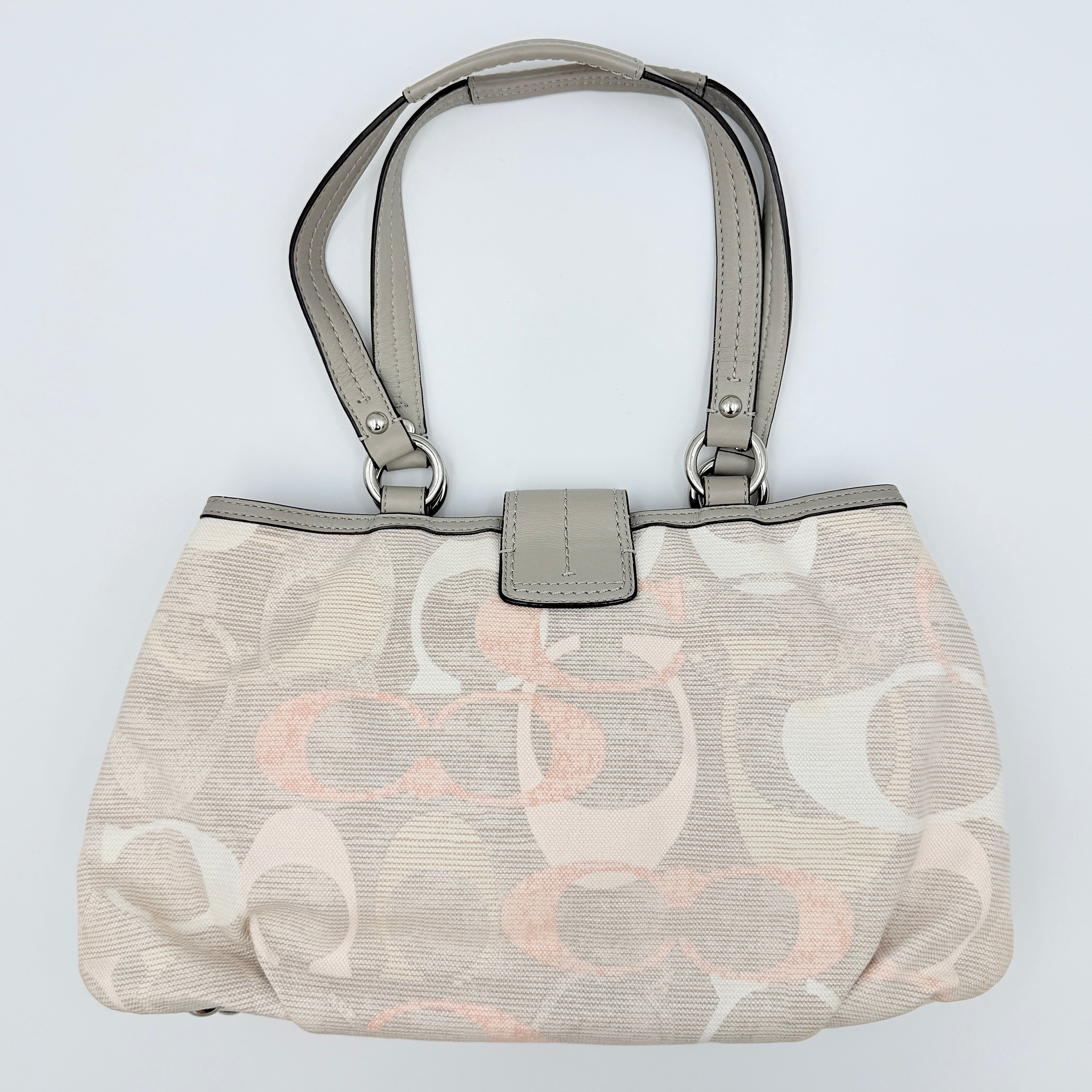 Coach Signature Optic Soho Shoulder Bag in grey and pink canvas with leather handles and buckle detail, shown against a white background.