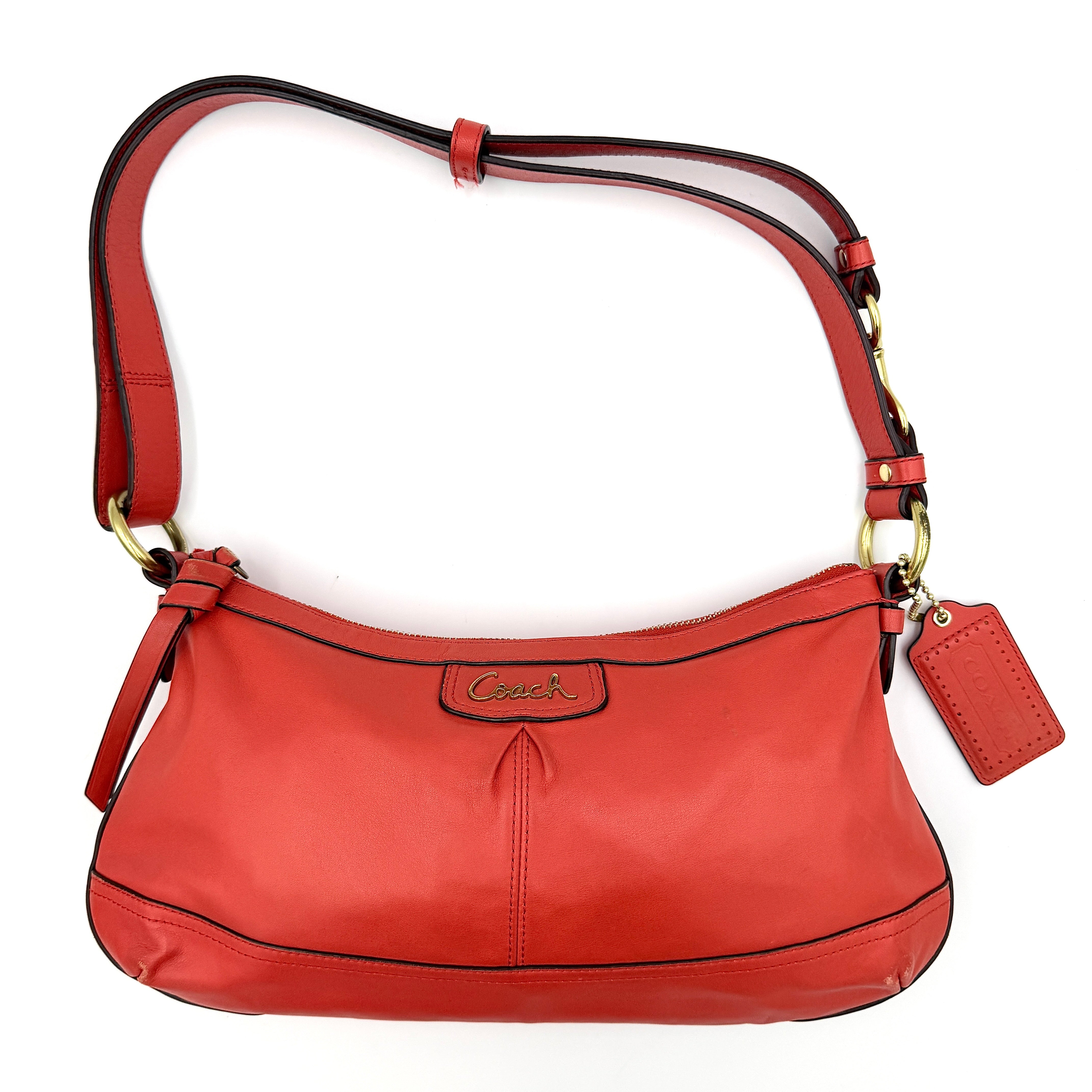 Coach 2Way Park Shoulder Bag in orange leather with gold hardware and adjustable strap, displayed against a white background.