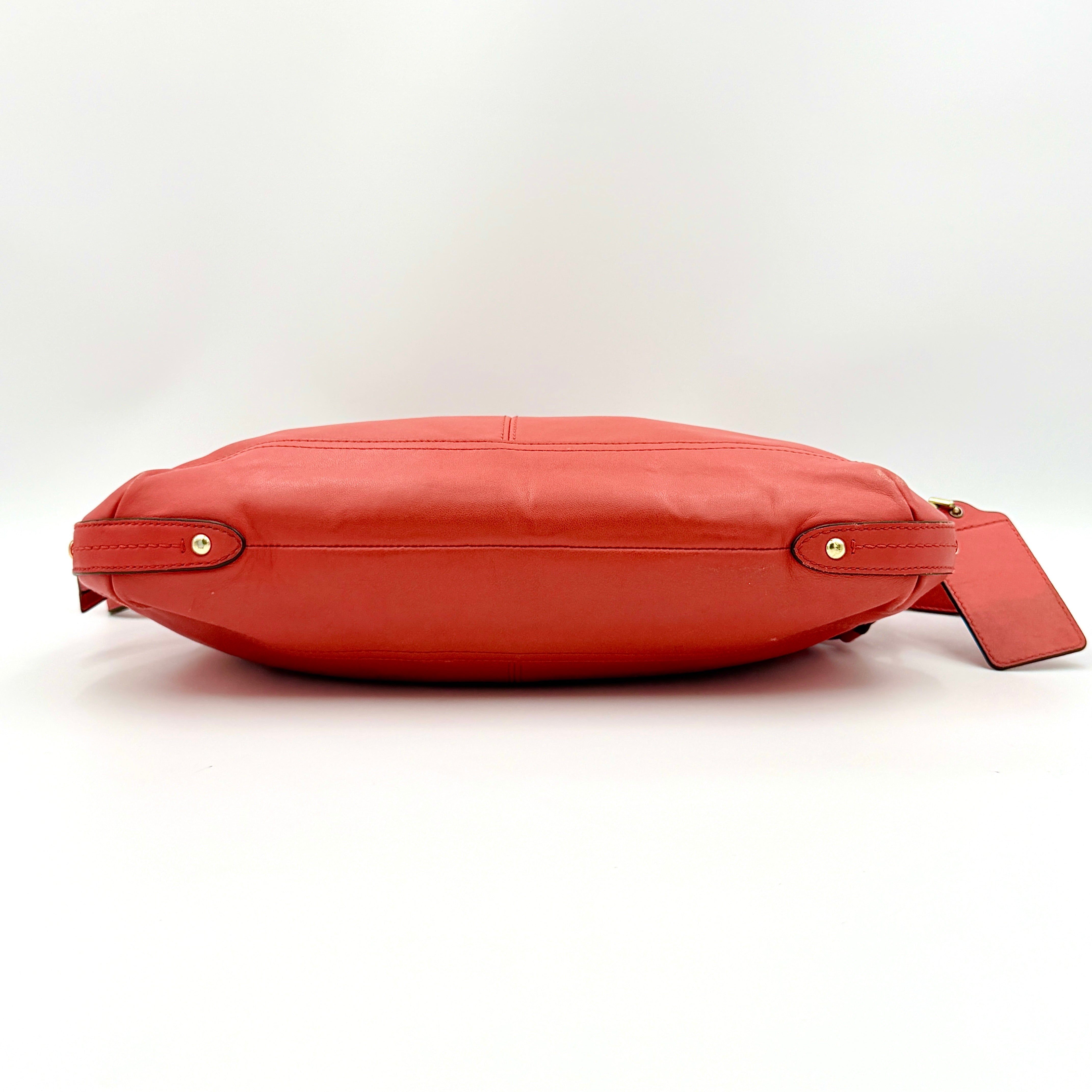 Coach 2Way Park Shoulder Bag in orange leather with gold hardware and adjustable strap, displayed against a white background.
