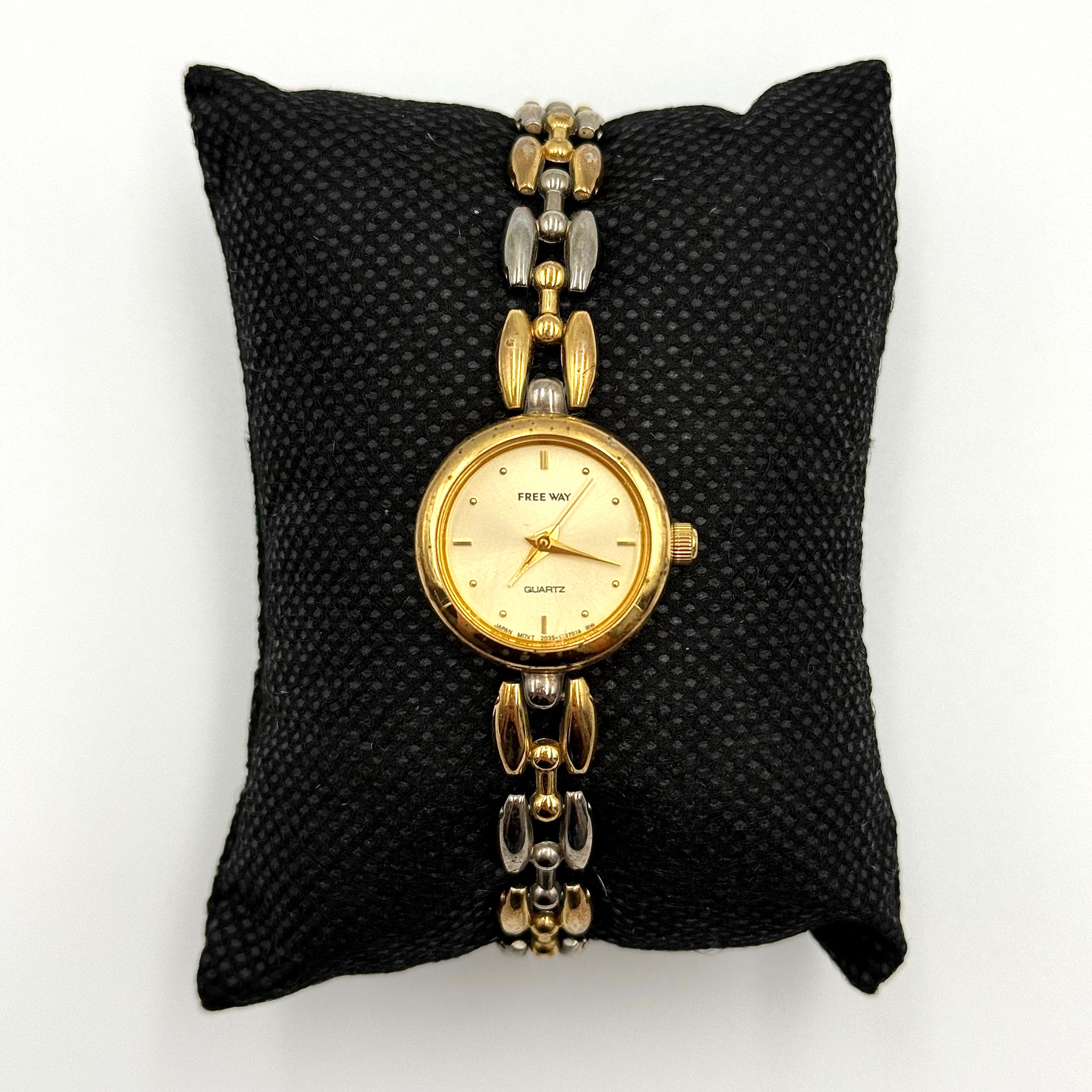 Citizen Free Way two-tone quartz watch with gold and silver link bracelet displayed on a black cushion.