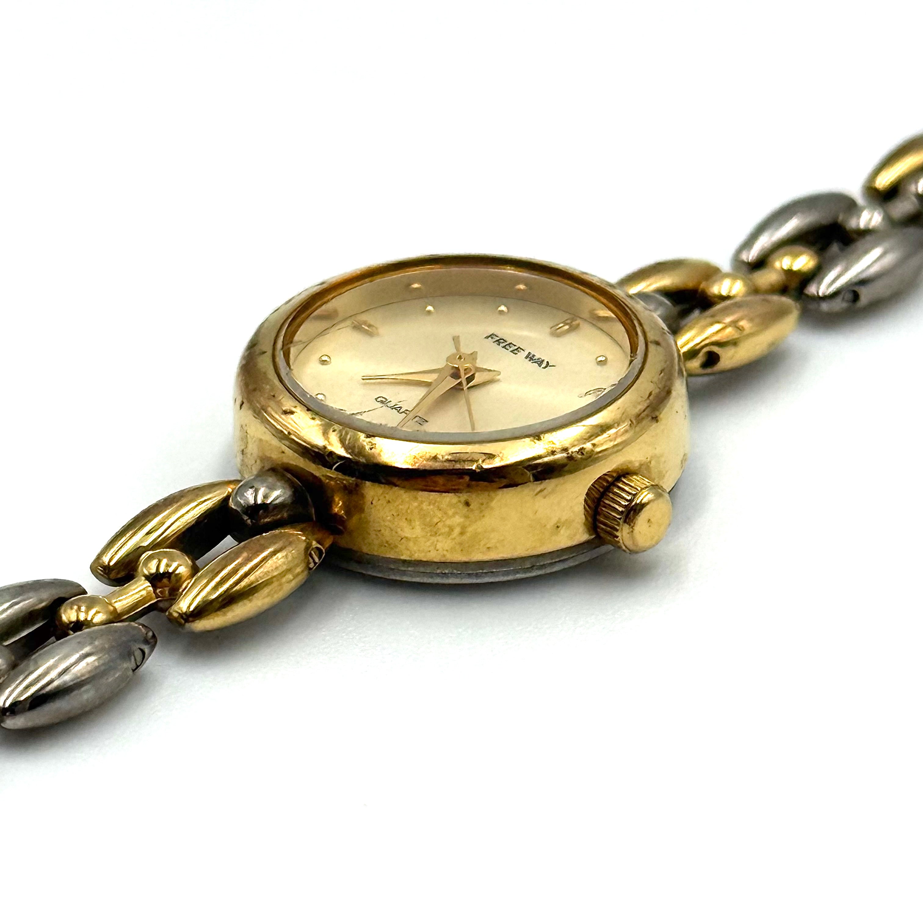 Citizen Free Way two-tone quartz watch with gold and silver link bracelet displayed on a black cushion.