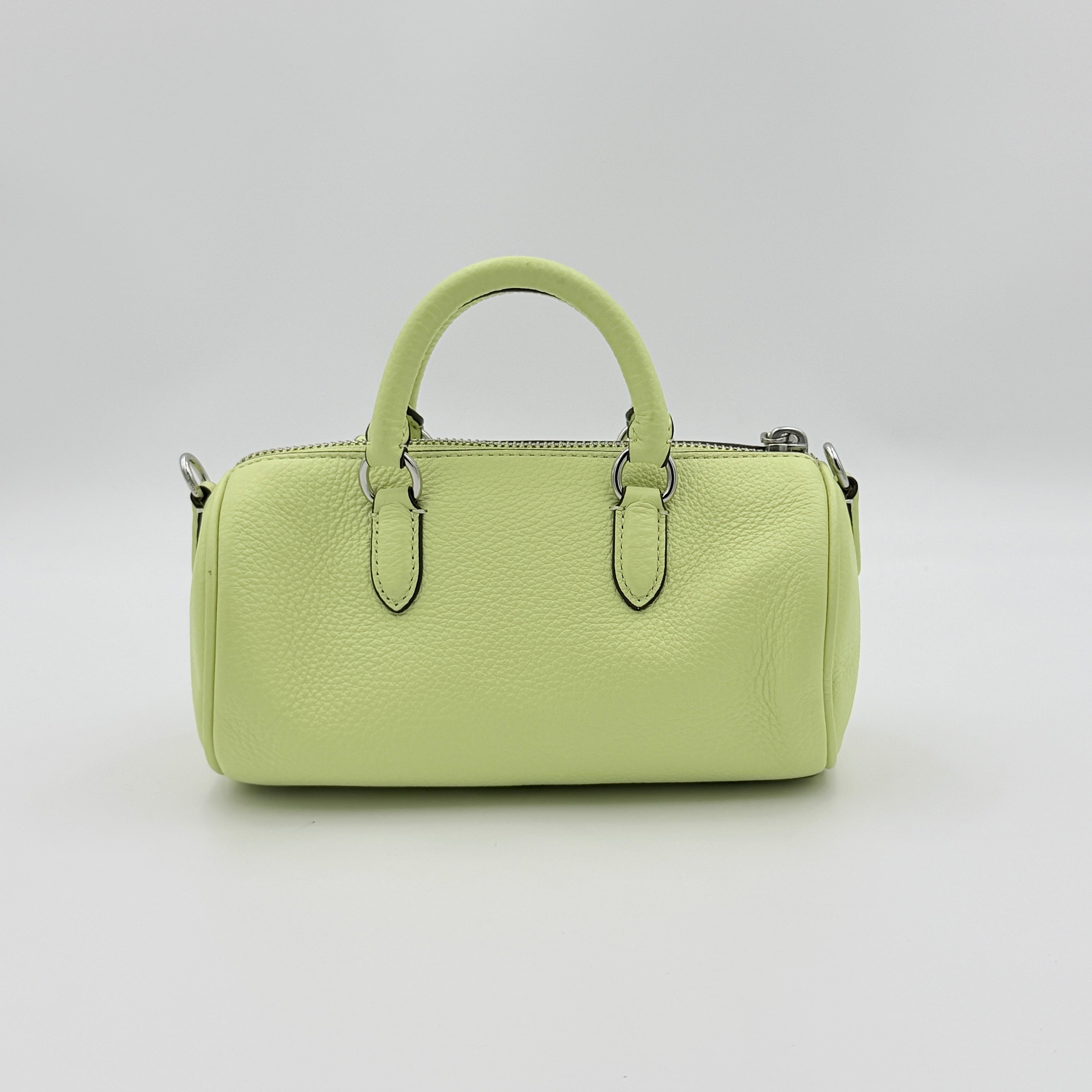 Coach 2Way Lacey Mini Boston Bag in light green pebbled leather with tassels and a detachable strap, shown against a plain background.
