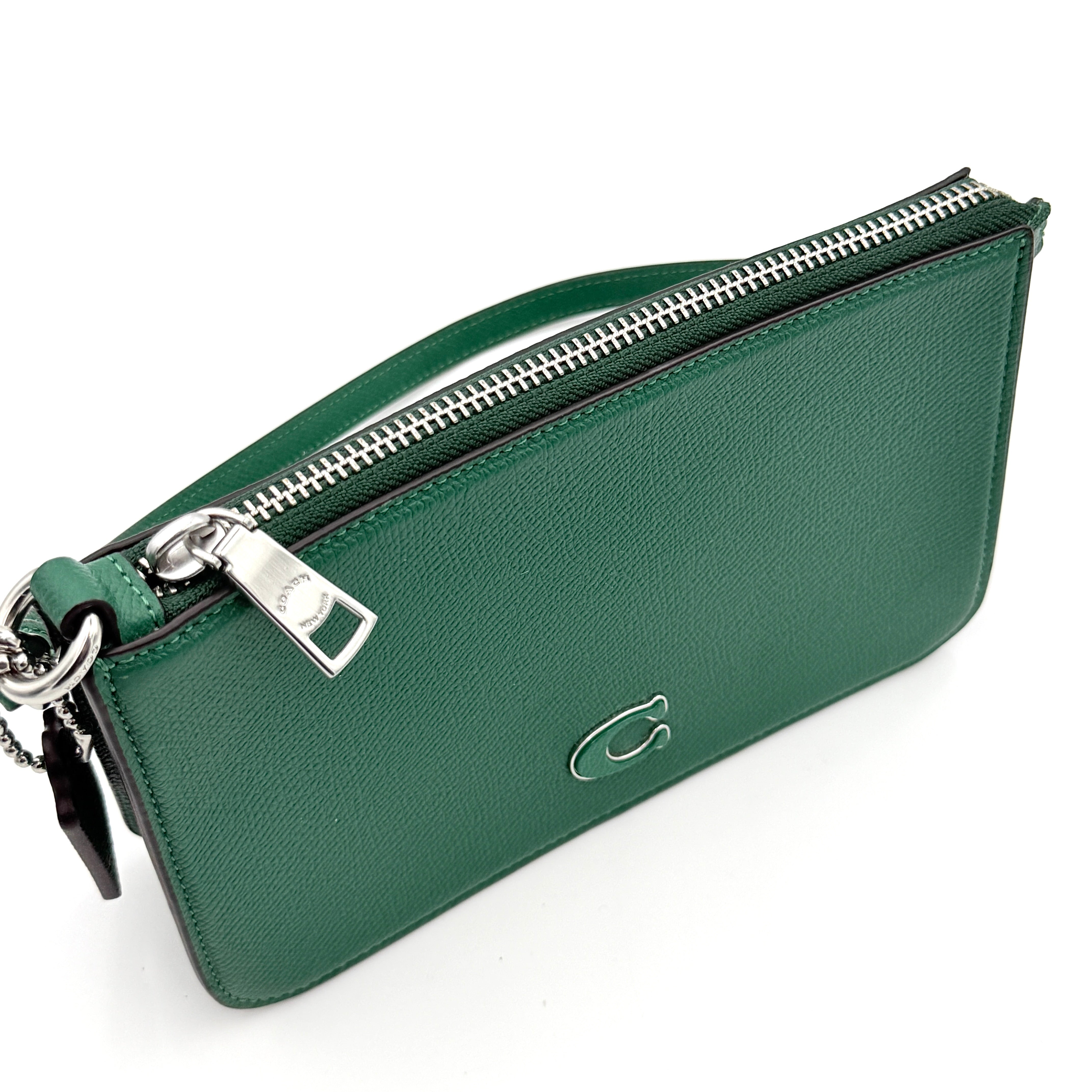 Coach green grained leather shoulder bag with silver C plaque and top zip, styled with a short strap.