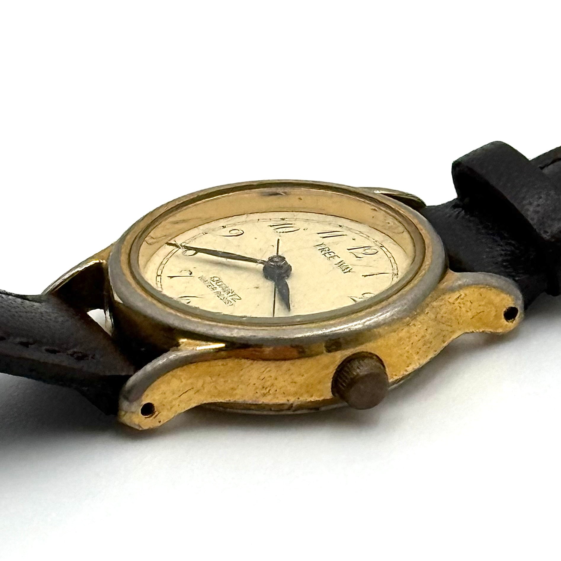 Citizen Freeway gold-tone quartz watch with black leather strap on a textured cushion