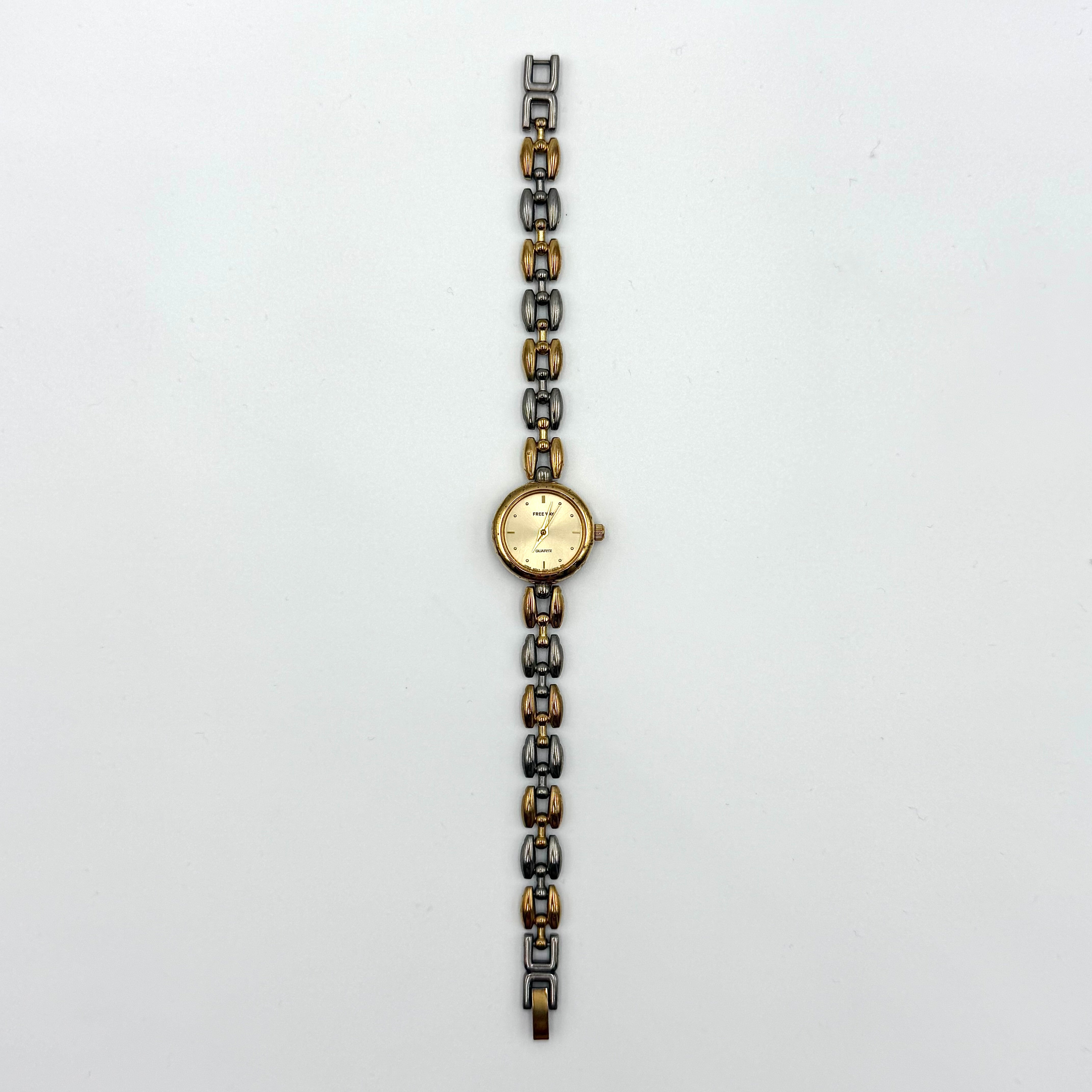 Citizen Free Way two-tone quartz watch with gold and silver link bracelet displayed on a black cushion.