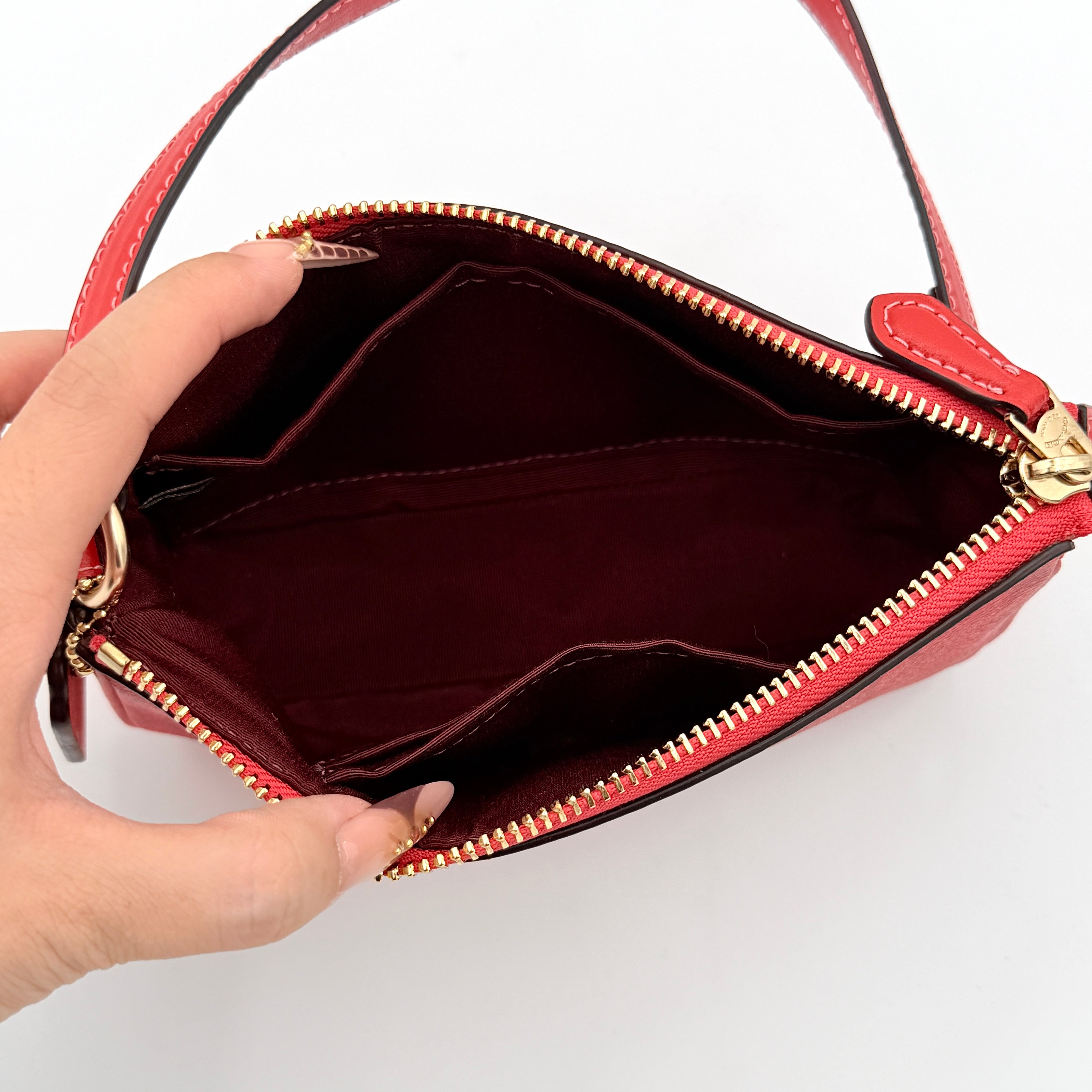 Coach Signature Nolita 19 Shoulder Bag in bright red coated canvas with signature pattern, gold-tone hardware and matching red hangtag.