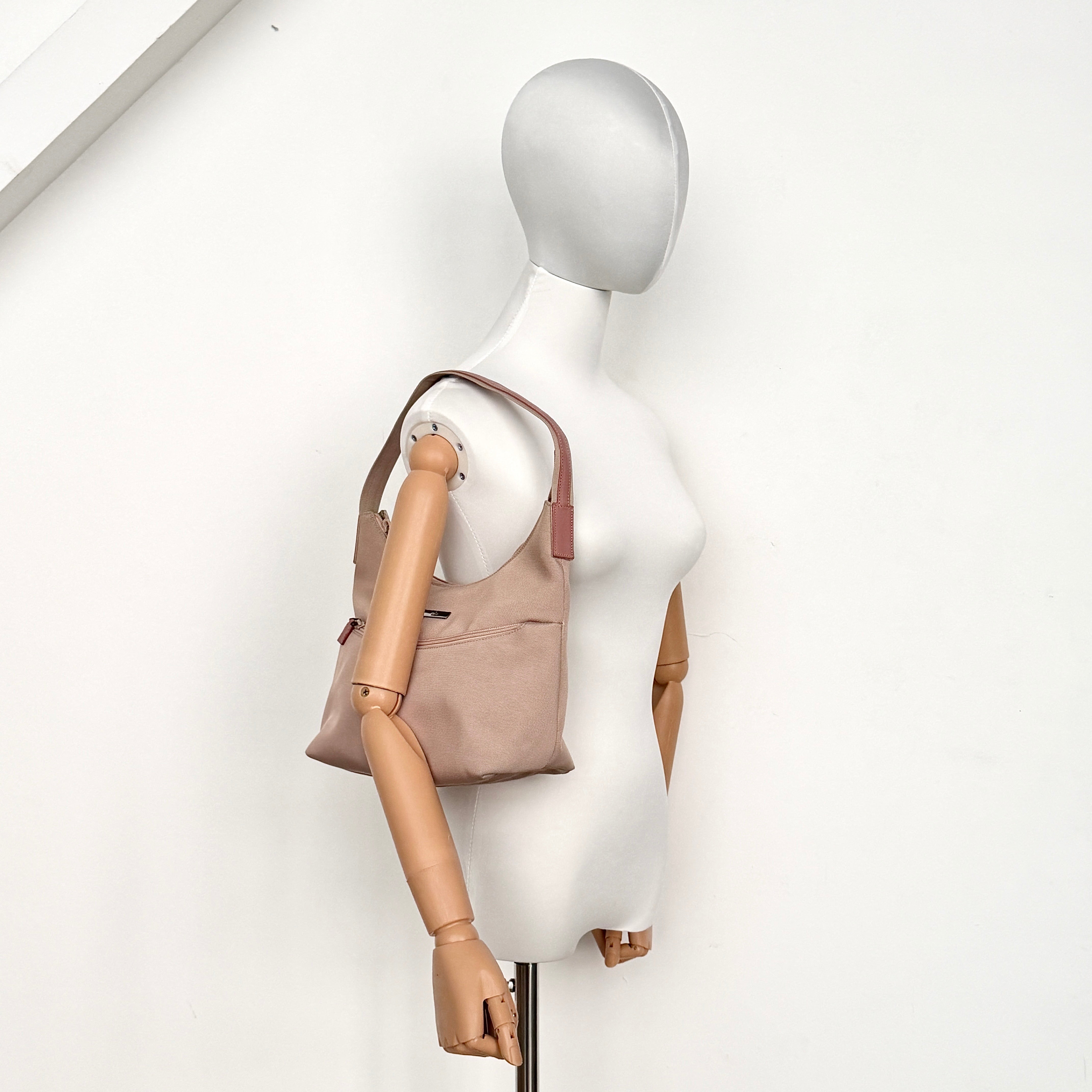 Gucci beige canvas hobo shoulder bag with pink leather accents and silver-tone hardware, displayed front-facing on a white background.