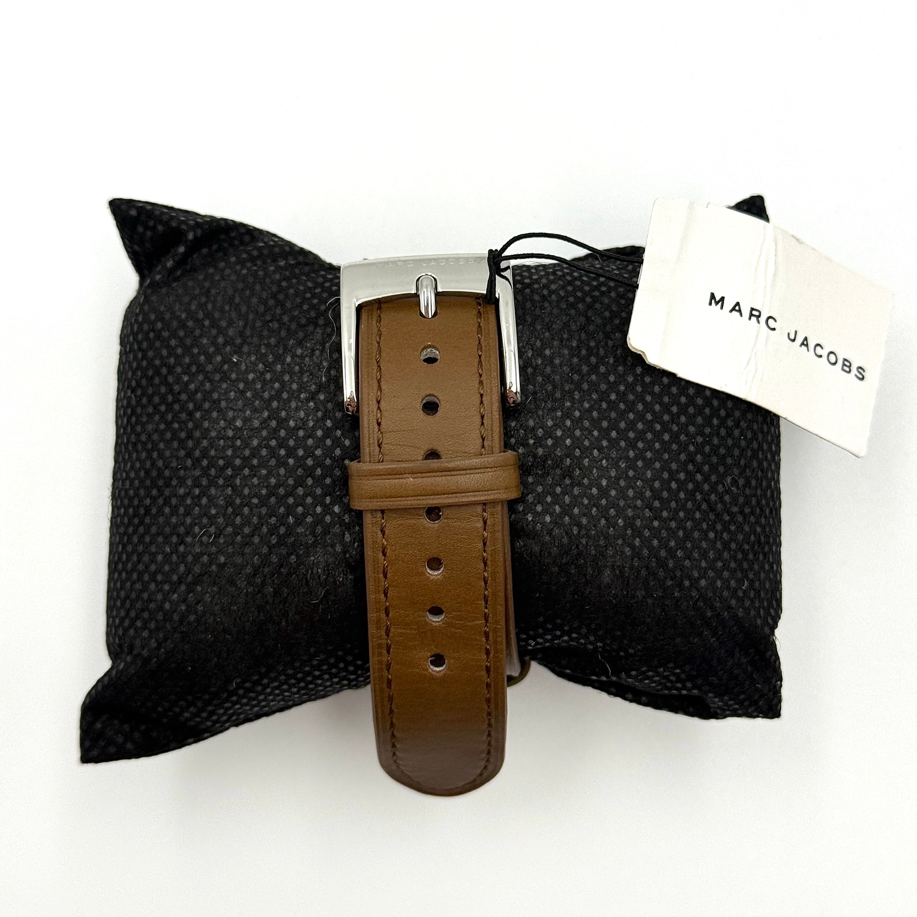 Marc Jacobs Courtney watch with silver stainless steel case and brown leather strap shown on a black cushion.