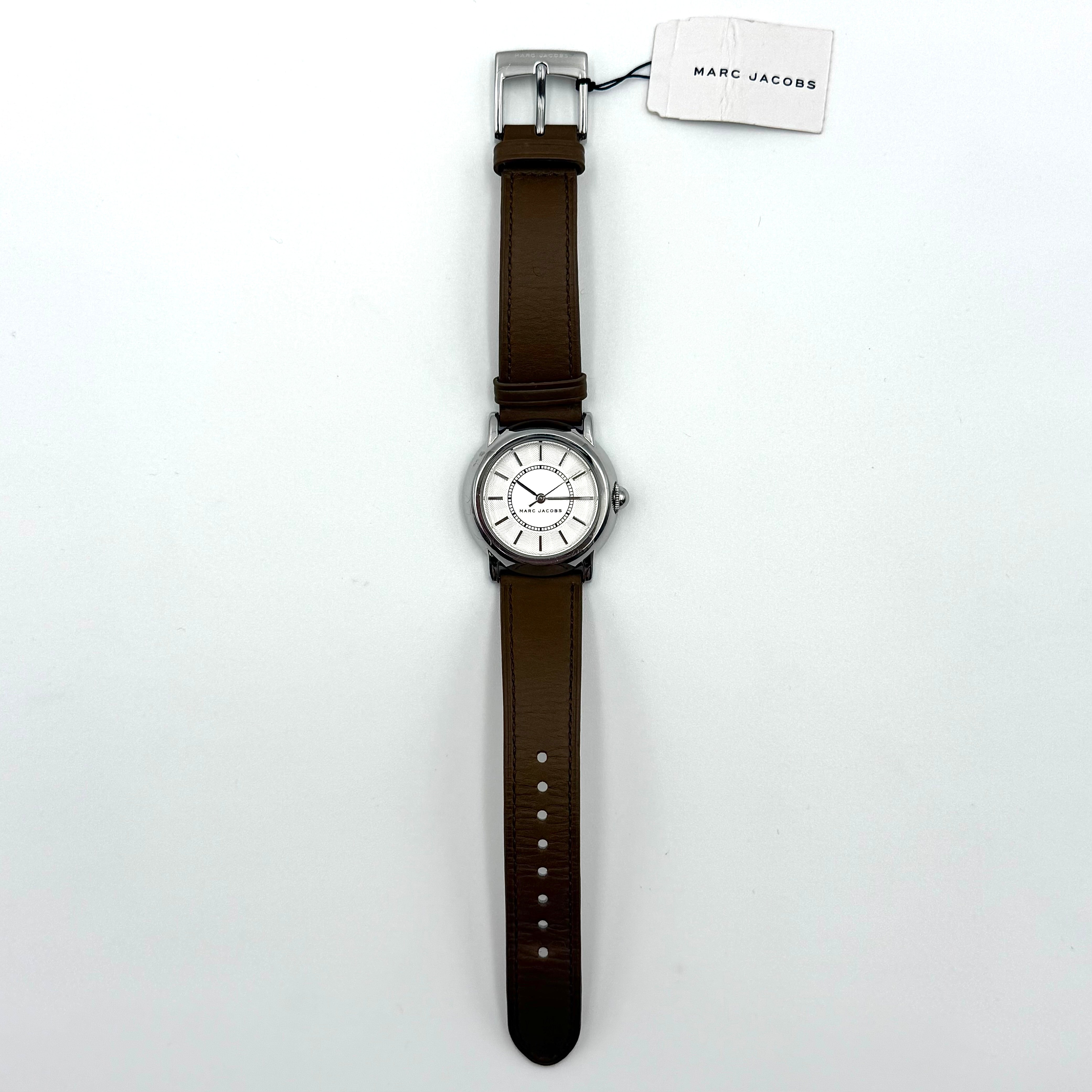 Marc Jacobs Courtney watch with silver stainless steel case and brown leather strap shown on a black cushion.