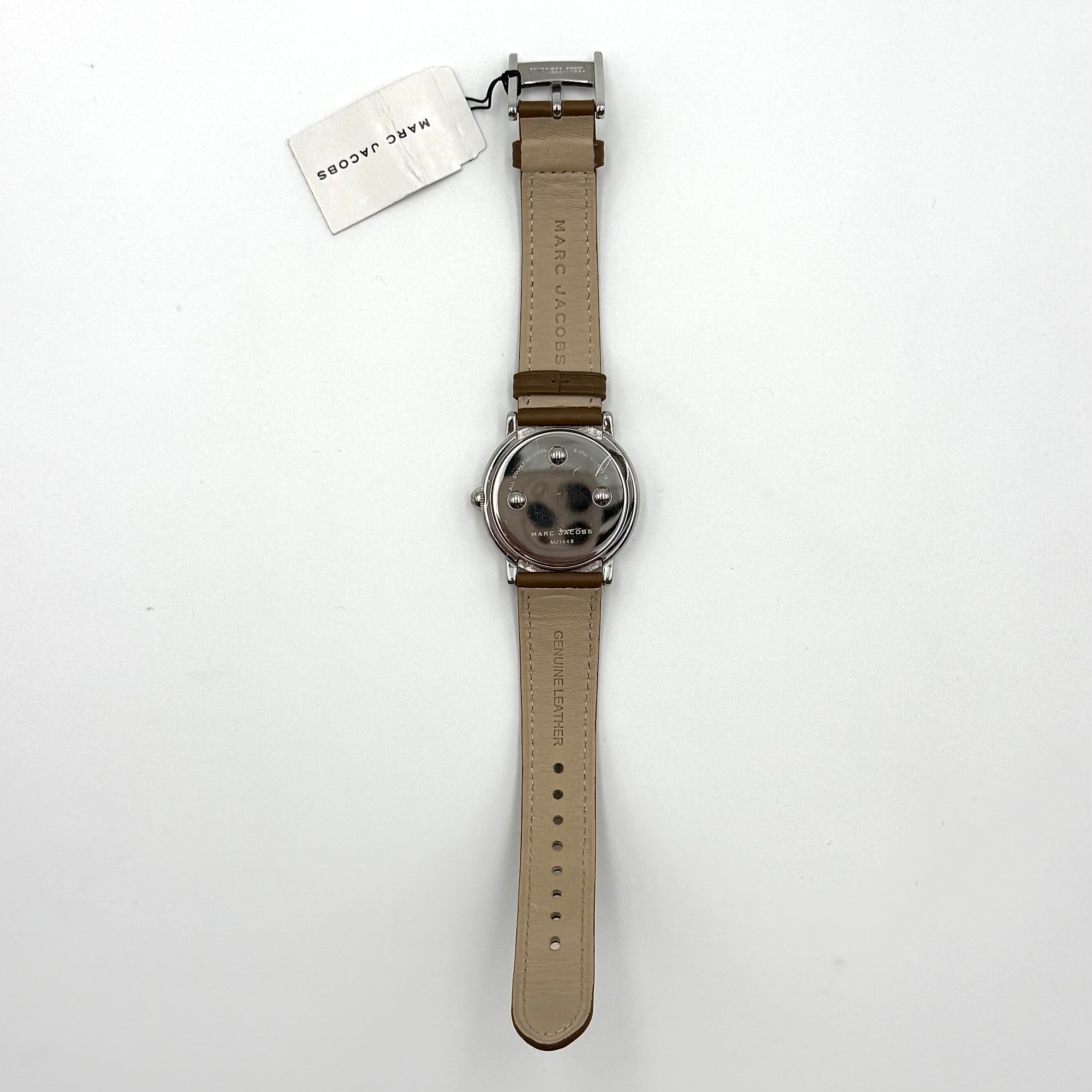 Marc Jacobs Courtney watch with silver stainless steel case and brown leather strap shown on a black cushion.