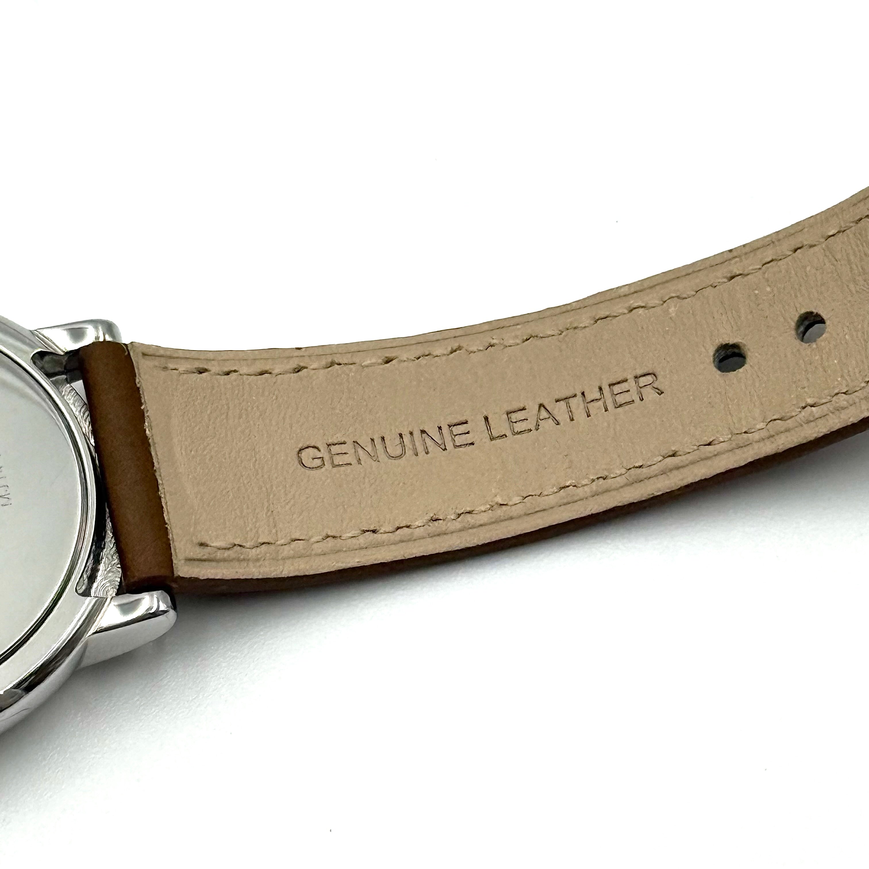 Marc Jacobs Courtney watch with silver stainless steel case and brown leather strap shown on a black cushion.