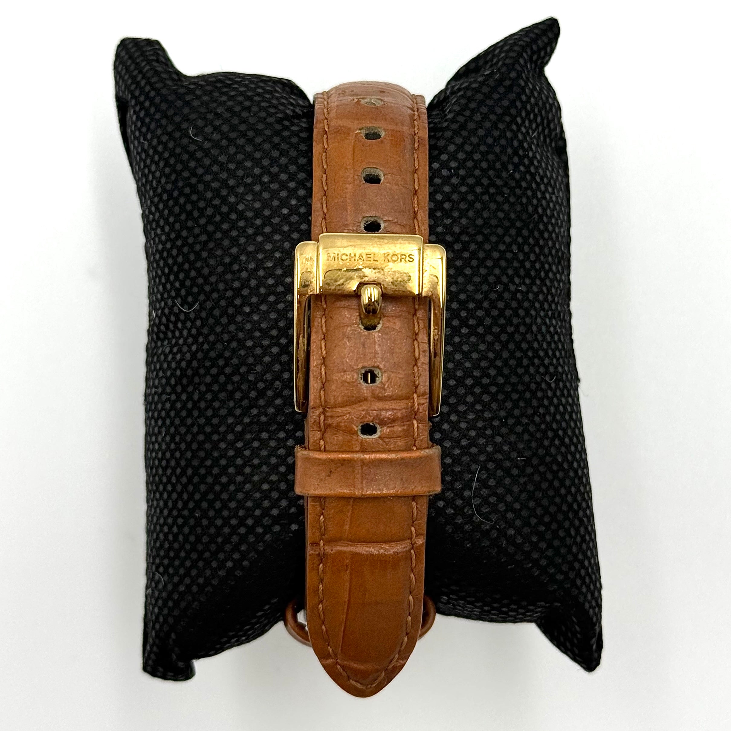 Michael Kors Whitley MK2428 watch with gold dial, crystal bezel and brown leather strap on black cushion