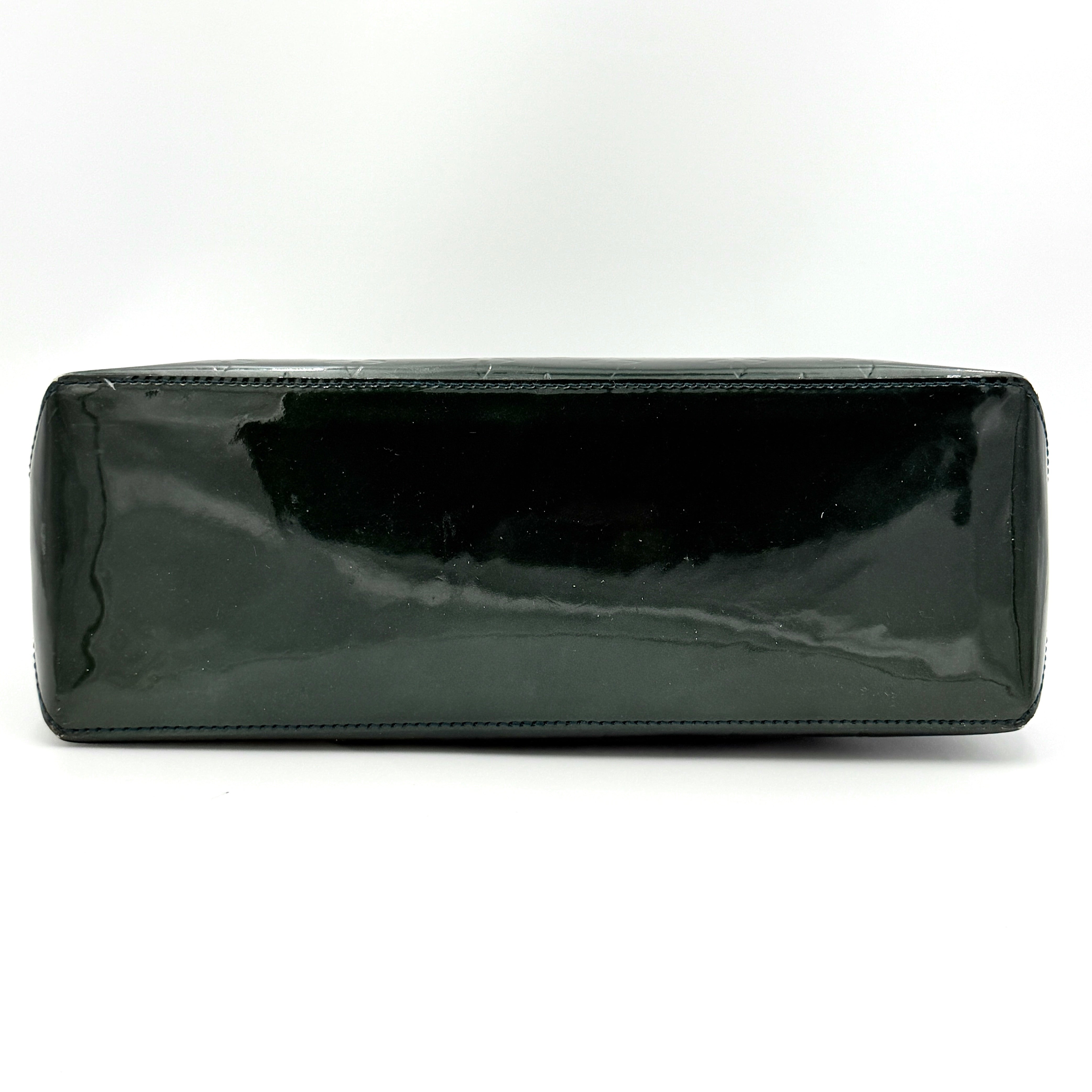 Louis Vuitton Wilshire PM bag in glossy dark green Monogram Vernis patent leather, shown with double top handles and gold-tone nameplate.