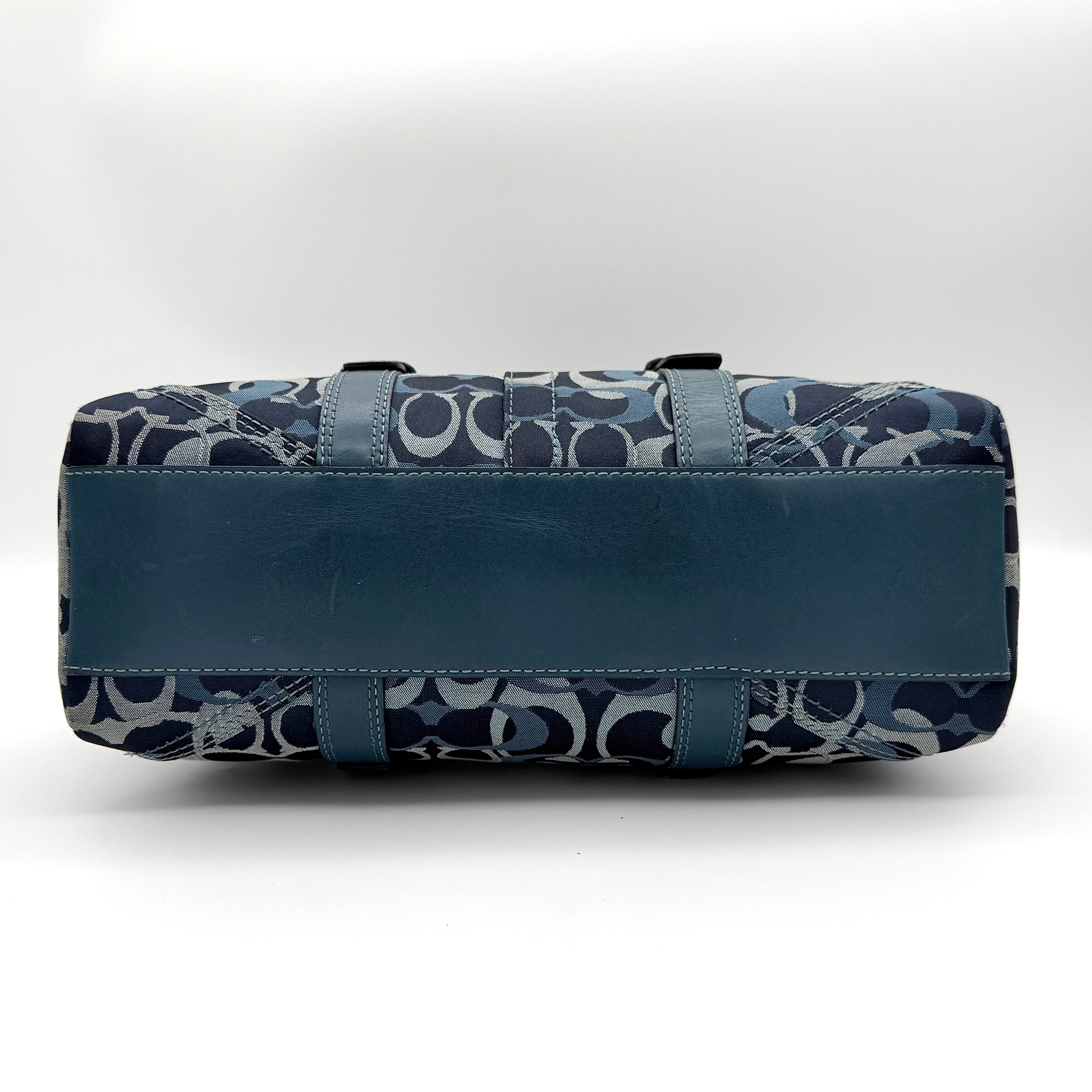 Coach Signature Chelsea Optic Satchel in blue canvas with leather braided handles and silver hardware, displayed on a Coach dust bag.