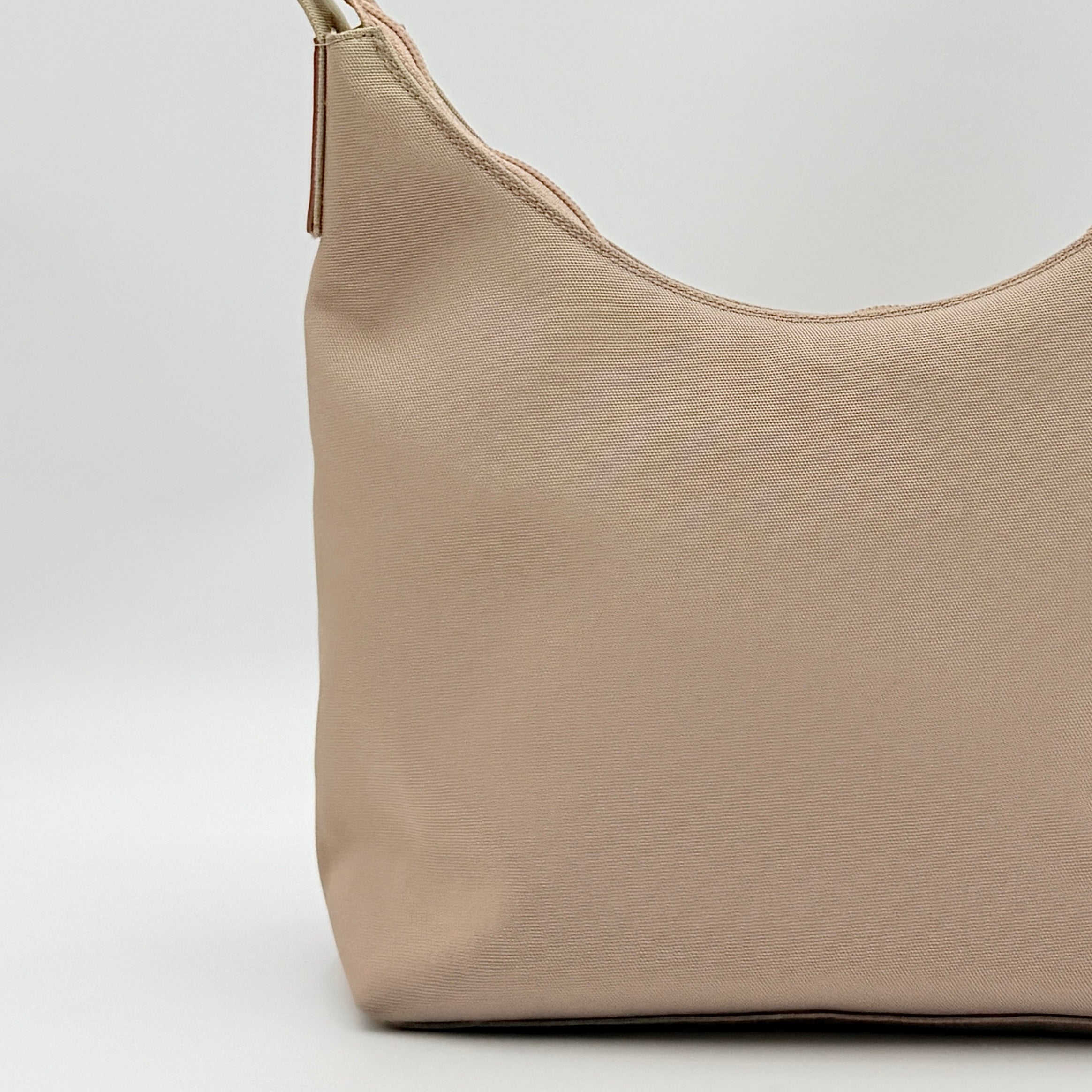 Gucci beige canvas hobo shoulder bag with pink leather accents and silver-tone hardware, displayed front-facing on a white background.