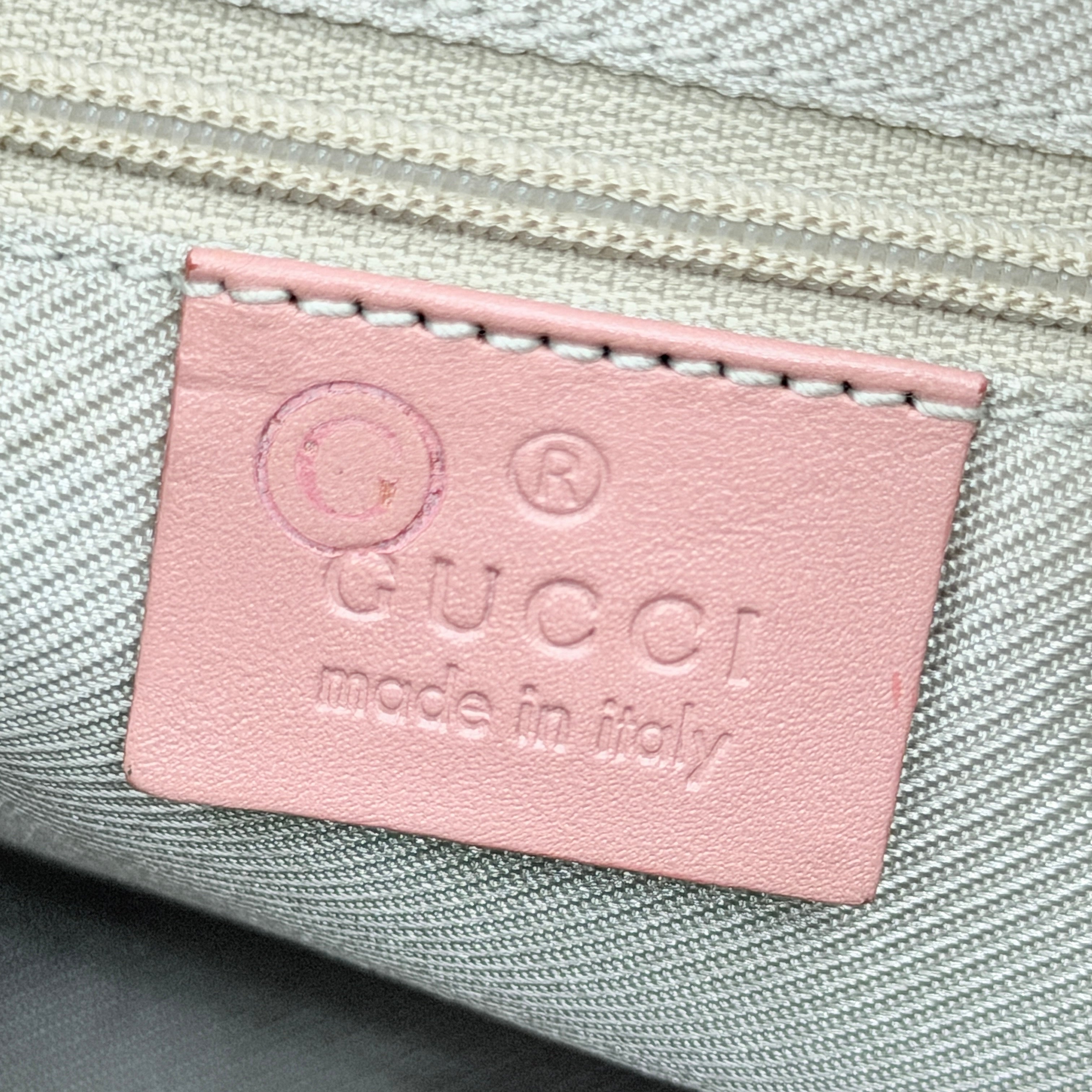 Gucci beige canvas hobo shoulder bag with pink leather accents and silver-tone hardware, displayed front-facing on a white background.