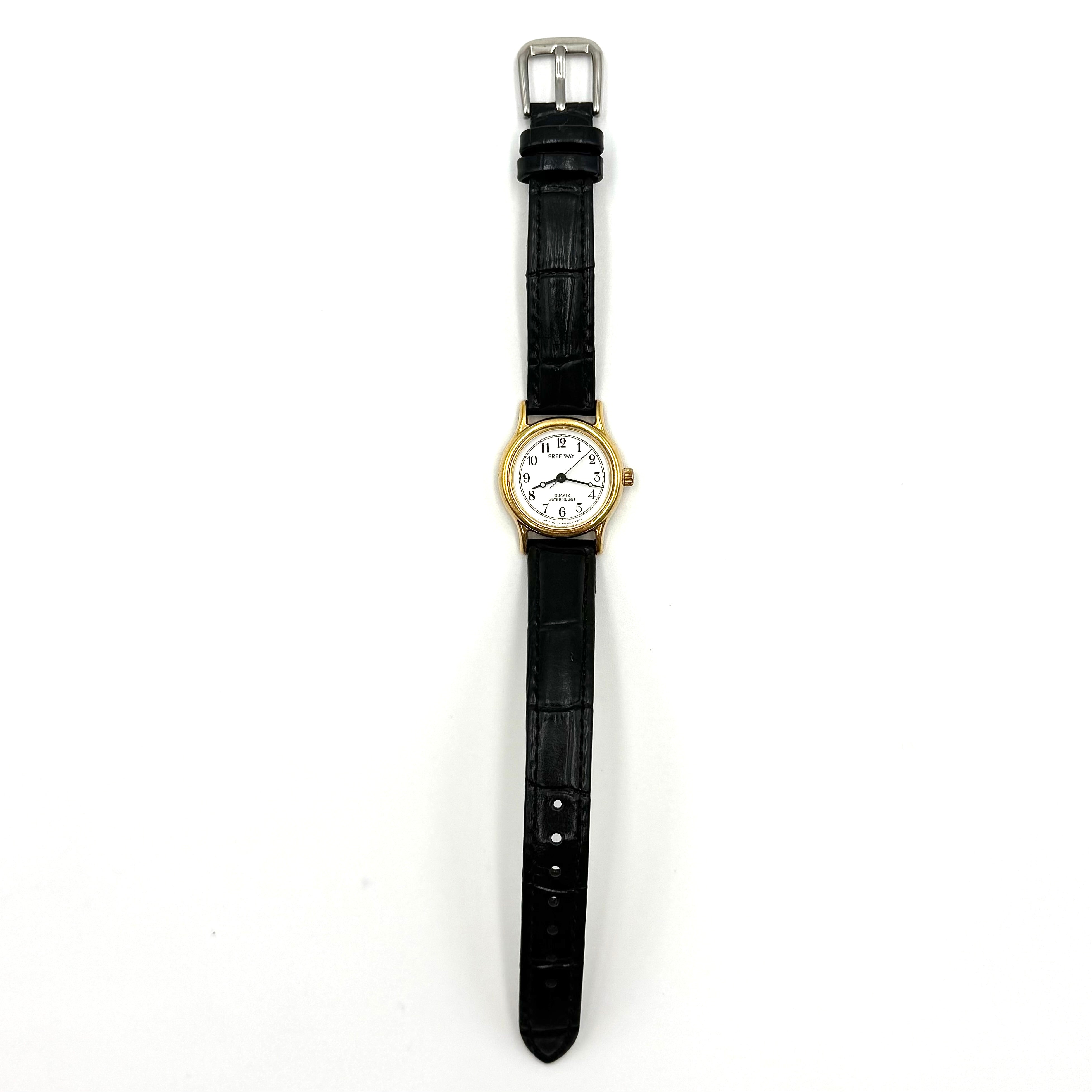 Citizen Freeway Quartz watch with white dial, gold case, and black leather strap displayed on a black cushion.