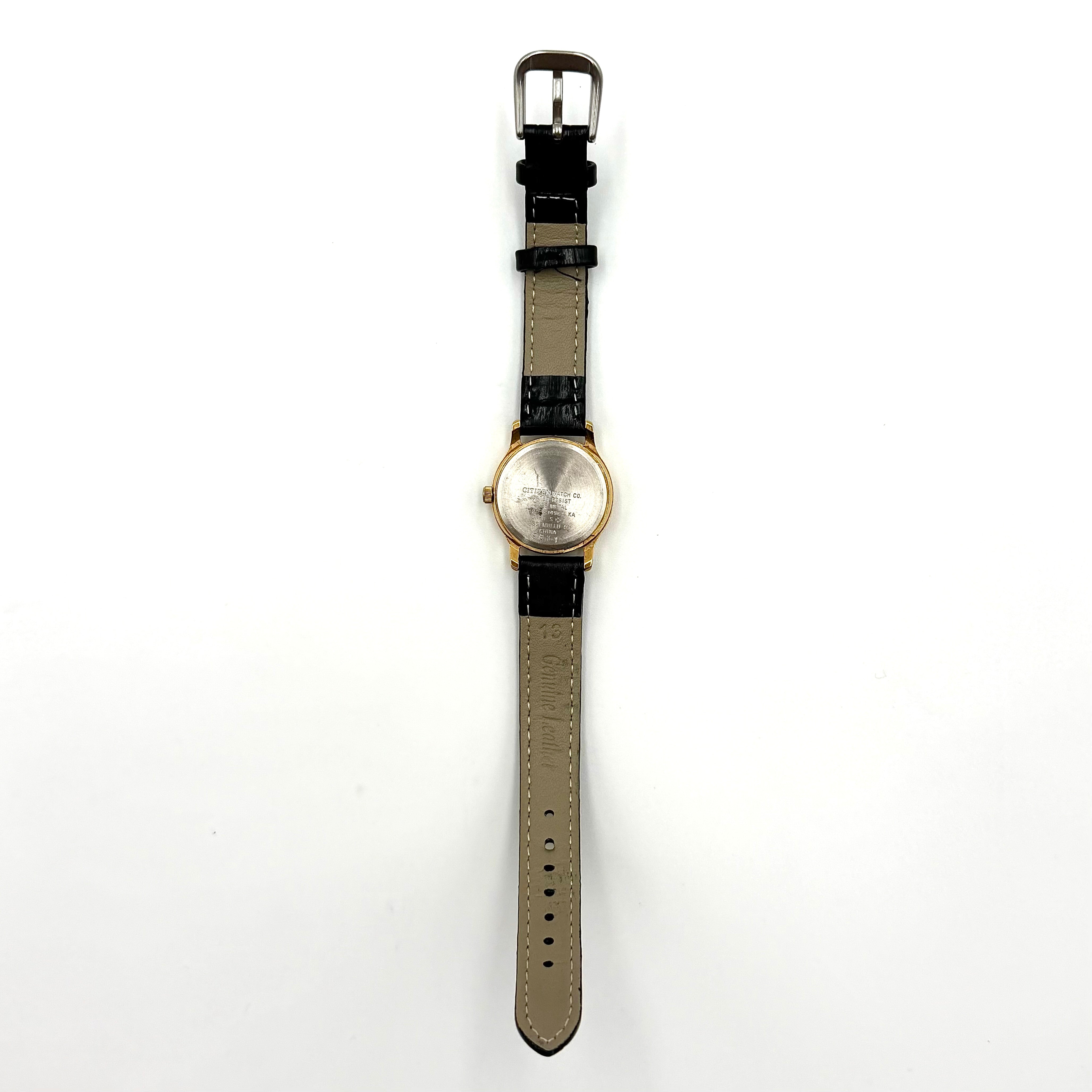 Citizen Freeway Quartz watch with white dial, gold case, and black leather strap displayed on a black cushion.