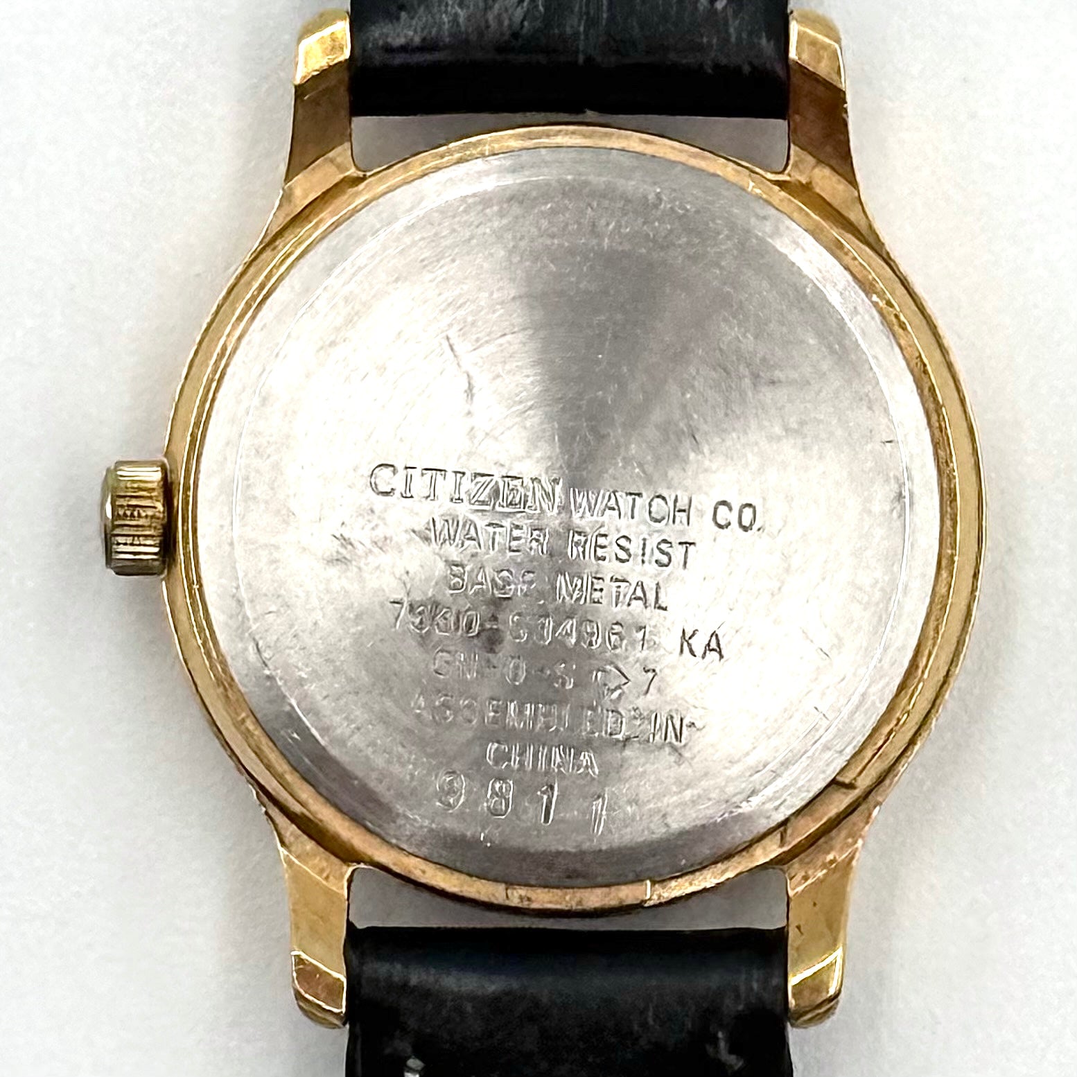 Citizen Freeway Quartz watch with white dial, gold case, and black leather strap displayed on a black cushion.