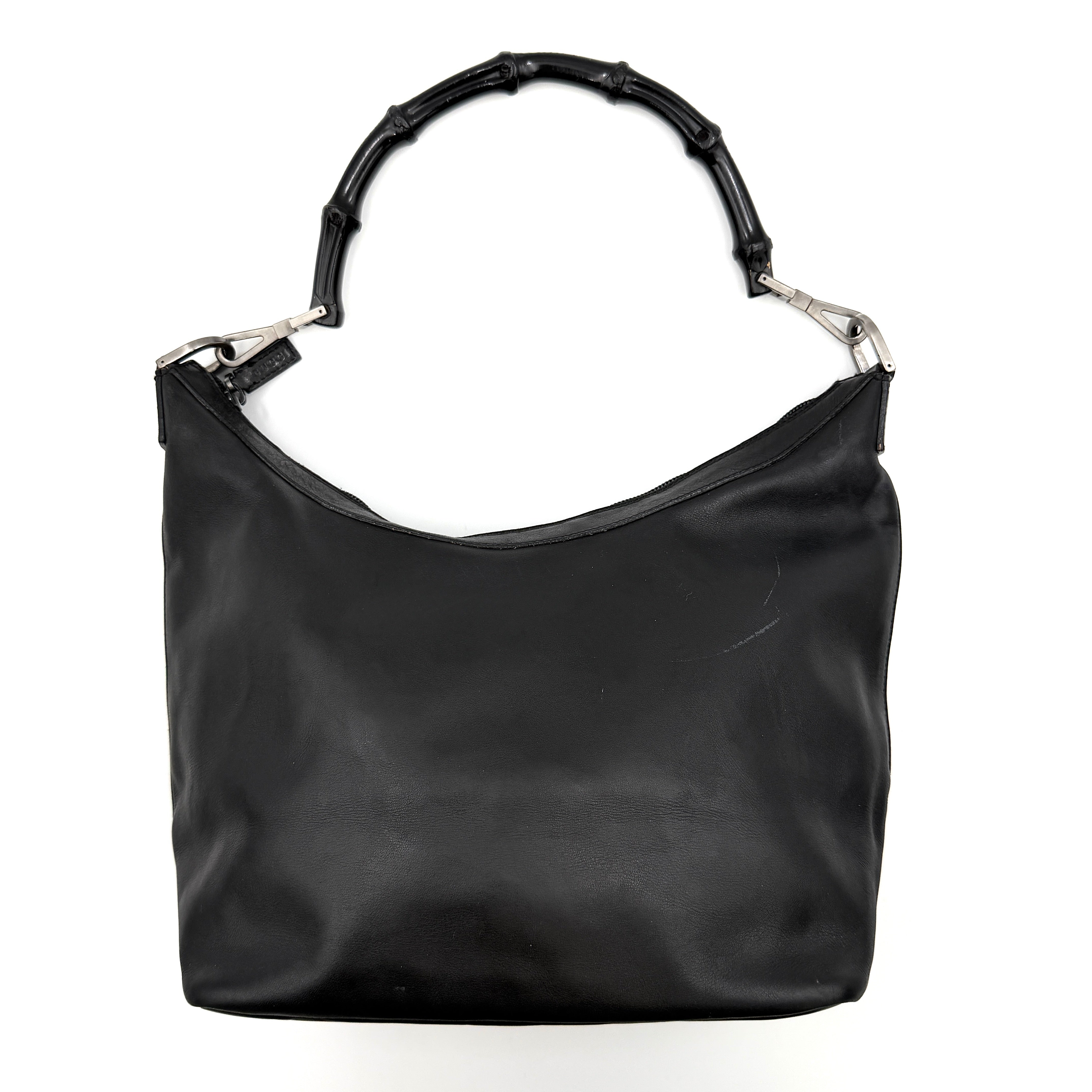 Gucci black leather hobo bag with bamboo handle and silver-tone hardware shown against a white background.