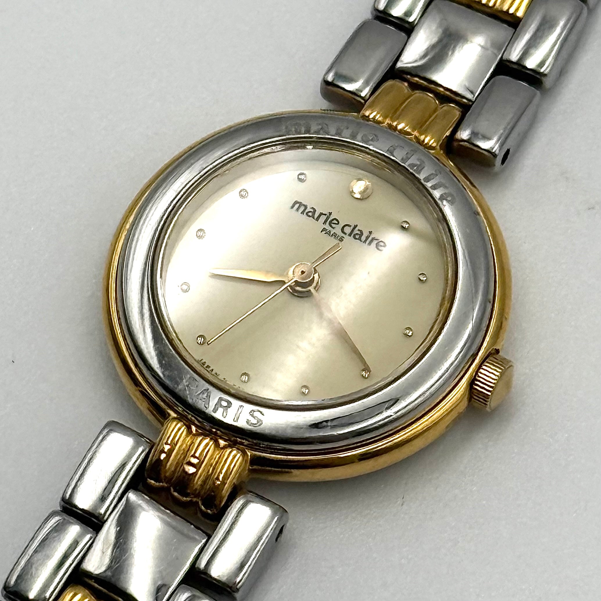 Marie Claire Paris 085268-00 two-tone gold and silver watch with a champagne dial, shown on a black pillow.