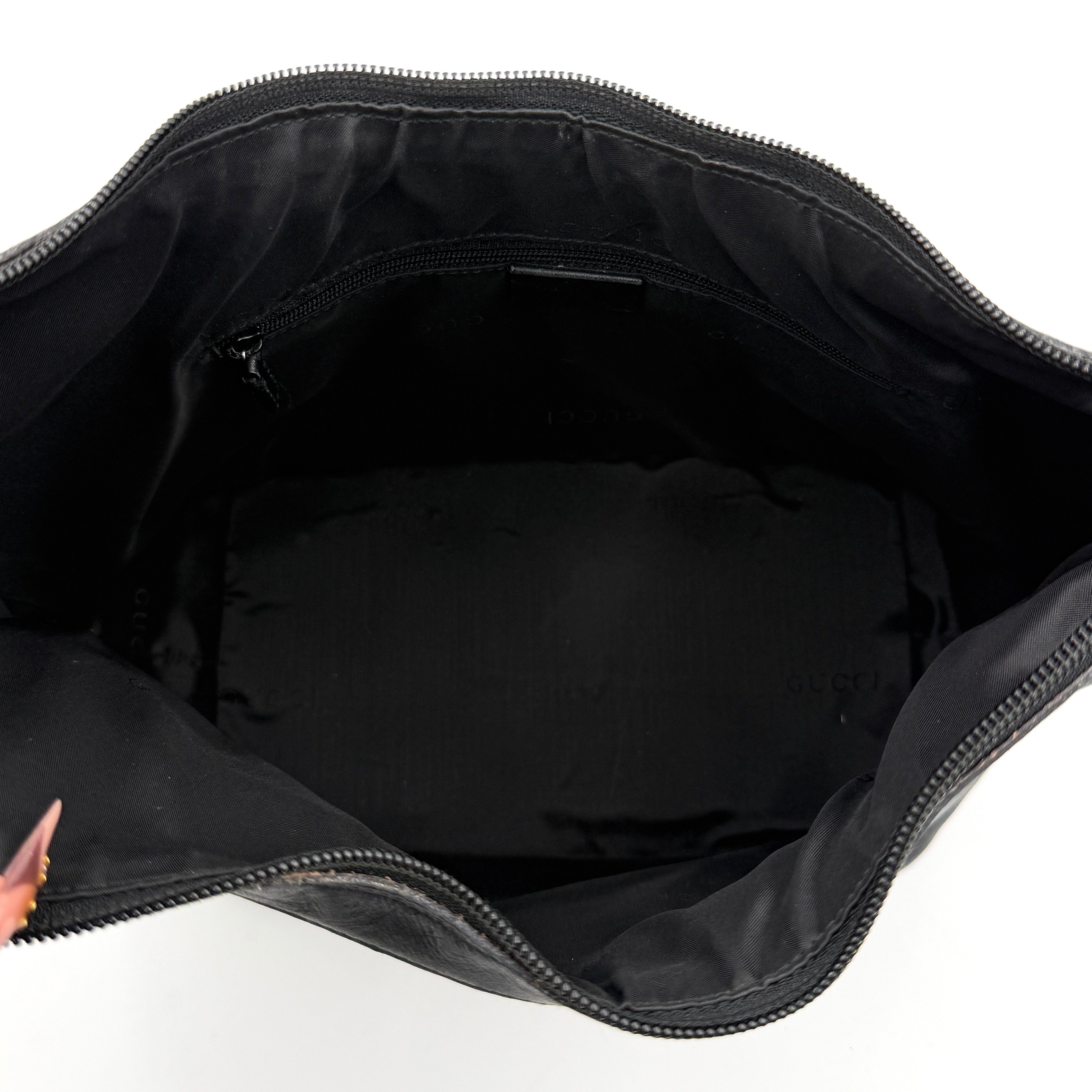 Gucci black leather hobo bag with bamboo handle and silver-tone hardware shown against a white background.