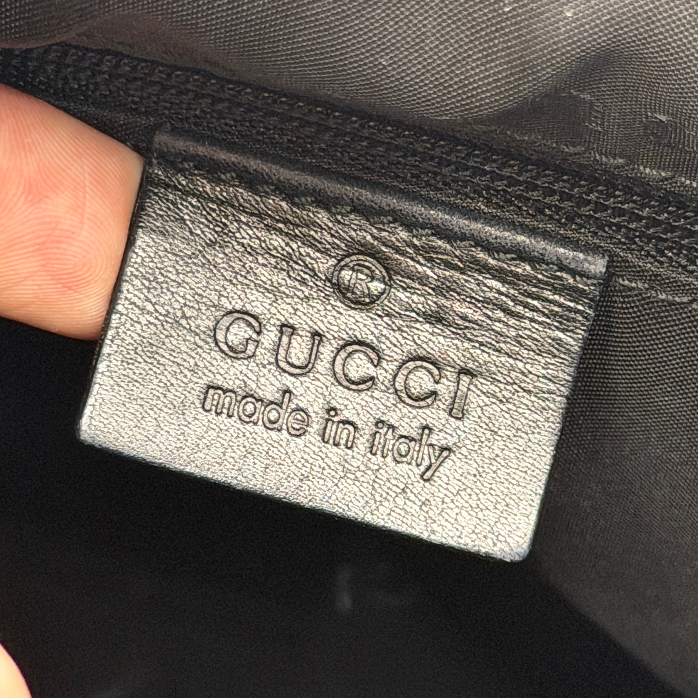 Gucci black leather hobo bag with bamboo handle and silver-tone hardware shown against a white background.