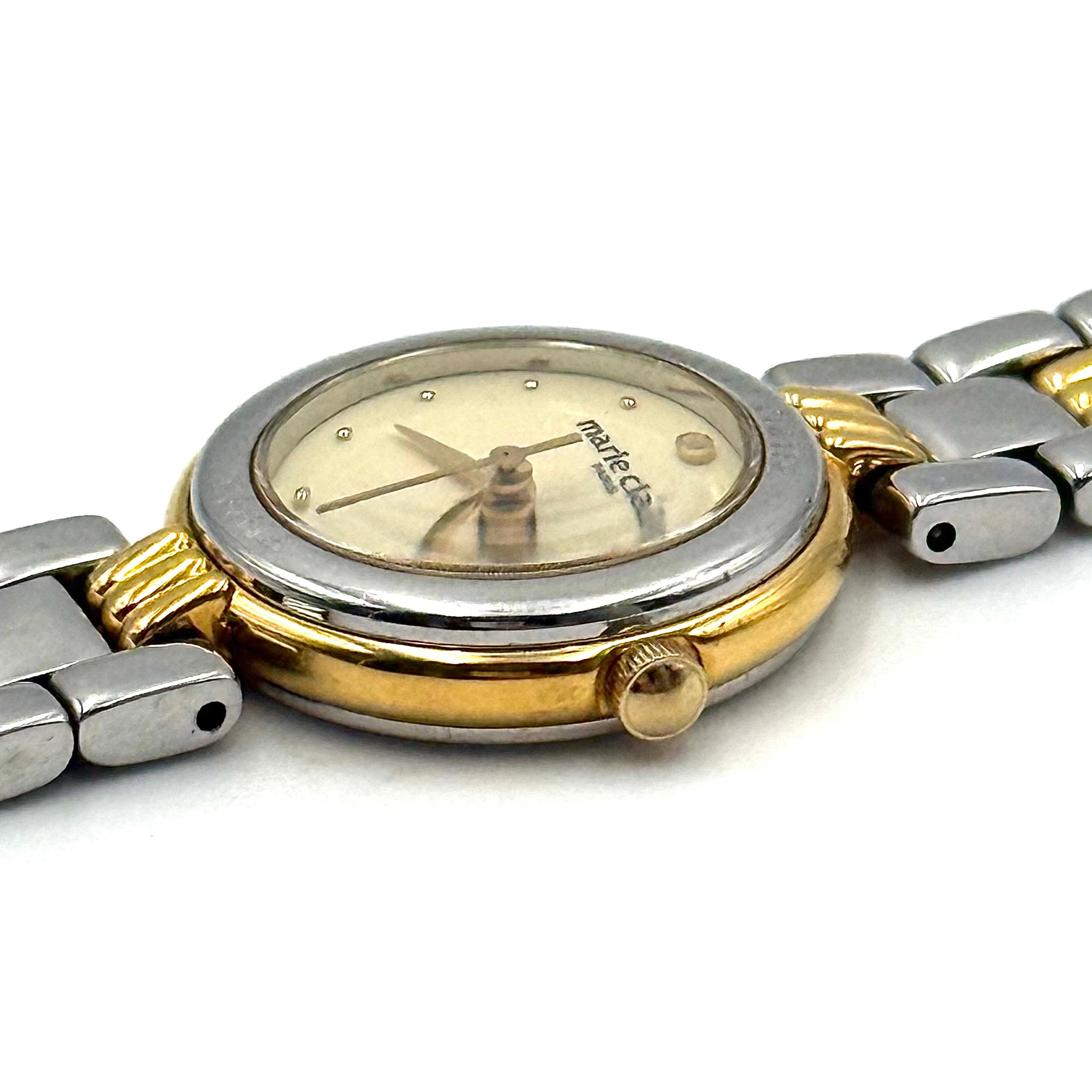 Marie Claire Paris 085268-00 two-tone gold and silver watch with a champagne dial, shown on a black pillow.