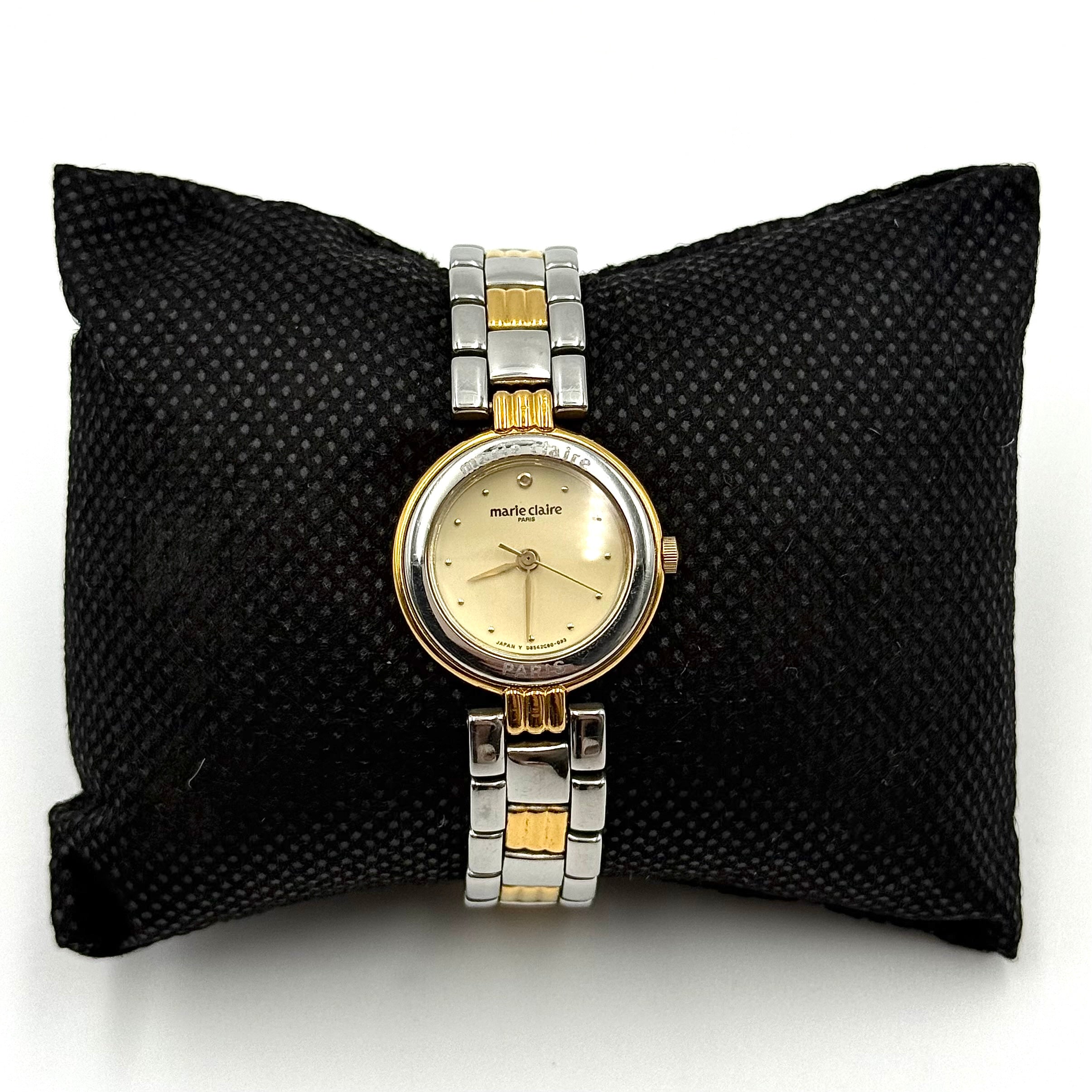 Marie Claire Paris 085268-00 two-tone gold and silver watch with a champagne dial, shown on a black pillow.