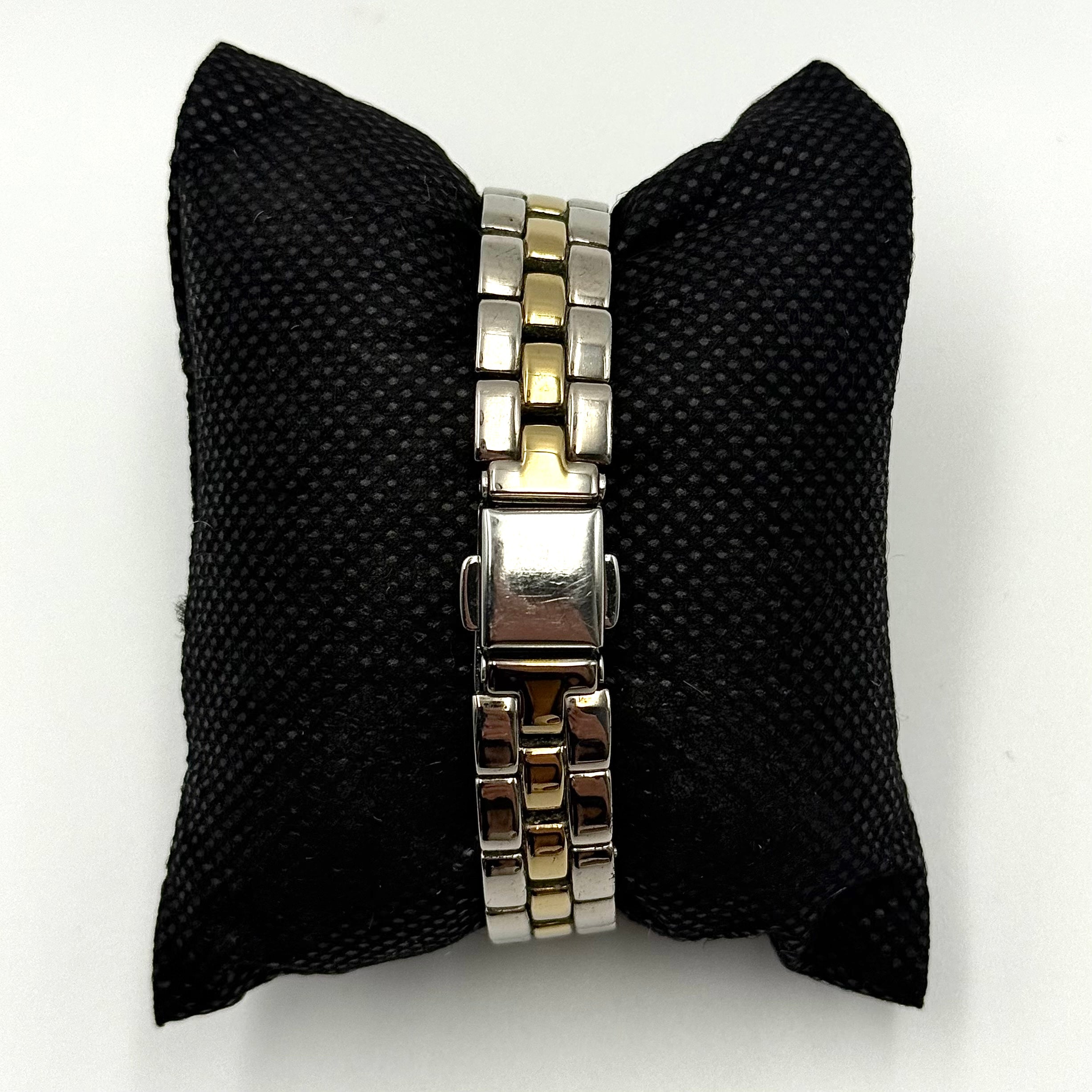 Citizen Reguno two-tone stainless steel watch in gold and silver with a round dial and linked bracelet, displayed on a black pillow.