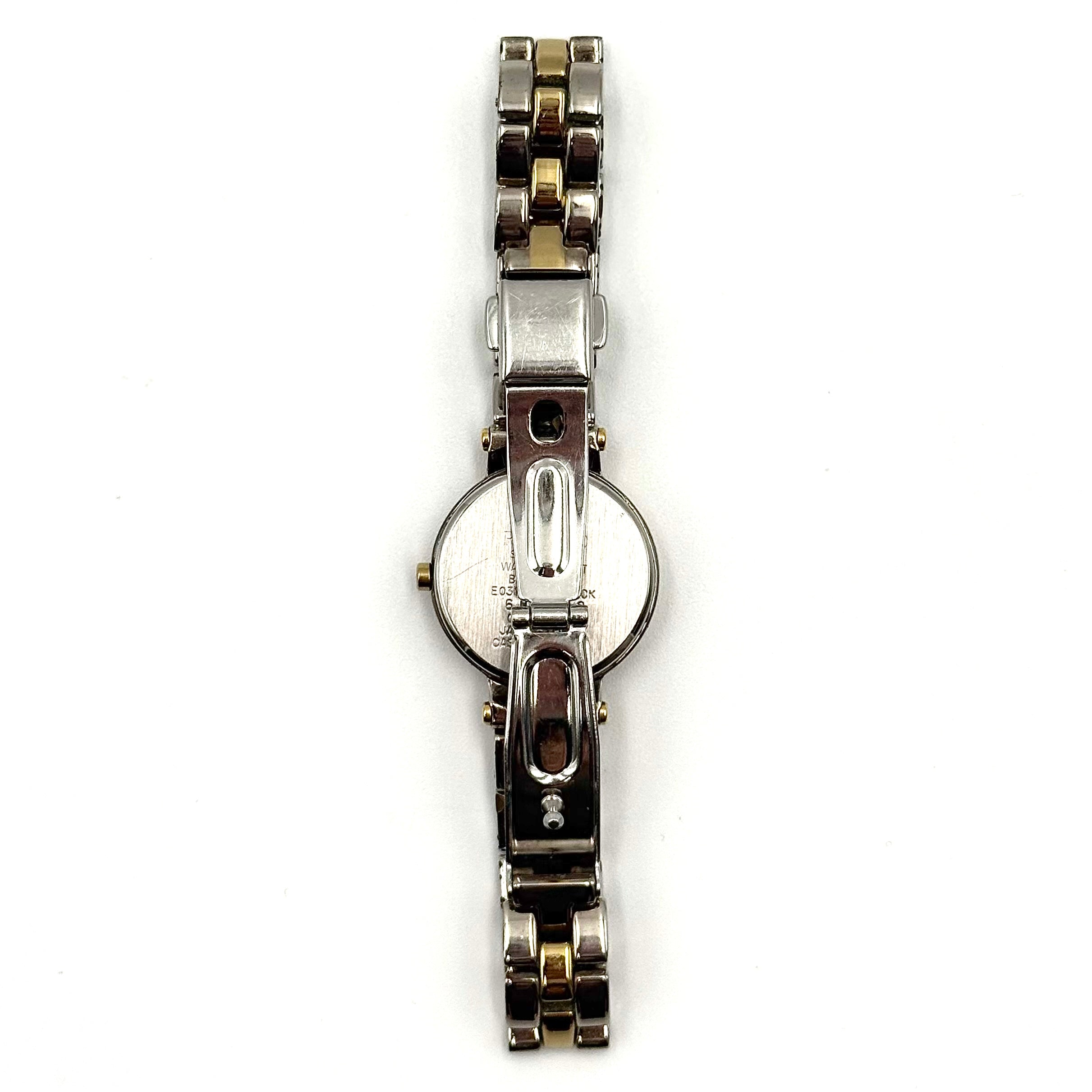 Citizen Reguno two-tone stainless steel watch in gold and silver with a round dial and linked bracelet, displayed on a black pillow.