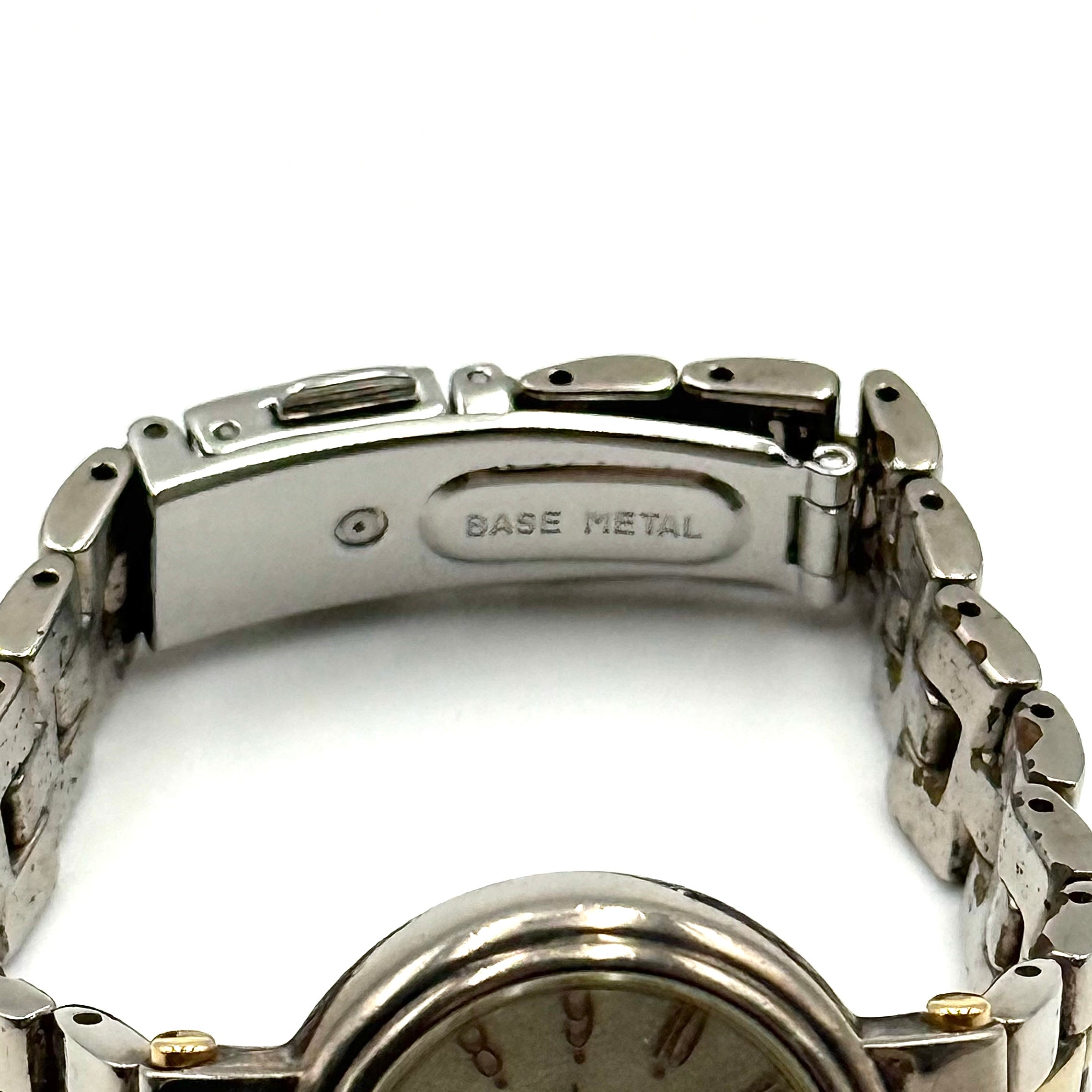 Citizen Reguno two-tone stainless steel watch in gold and silver with a round dial and linked bracelet, displayed on a black pillow.