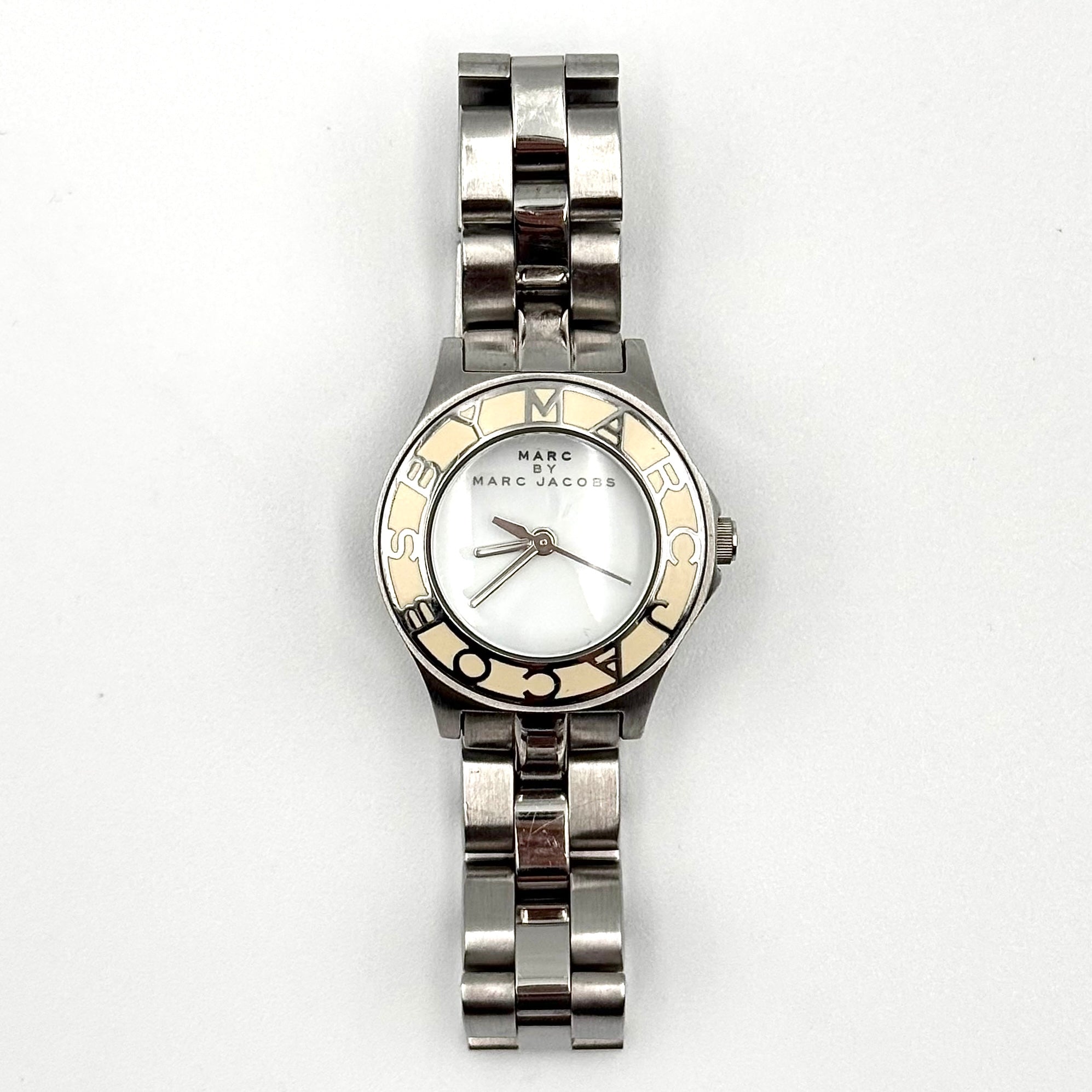 Marc Jacobs Blade MBM3049 watch in stainless steel with a cream bezel, shown on a black cushion.