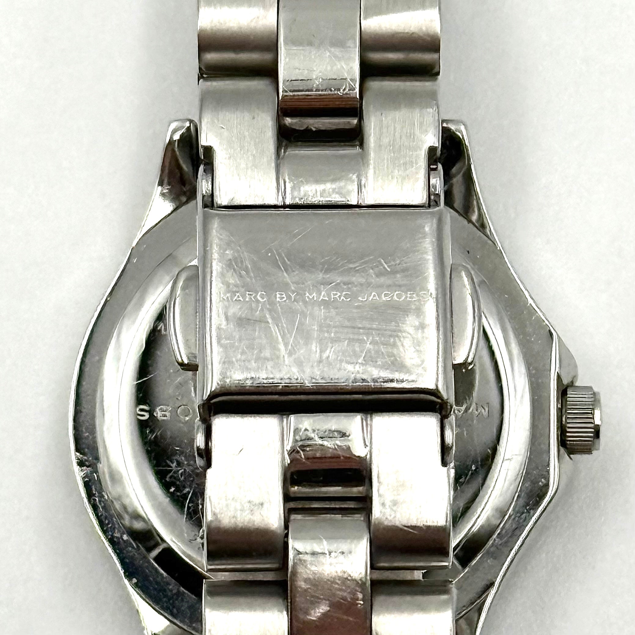 Marc Jacobs Blade MBM3049 watch in stainless steel with a cream bezel, shown on a black cushion.