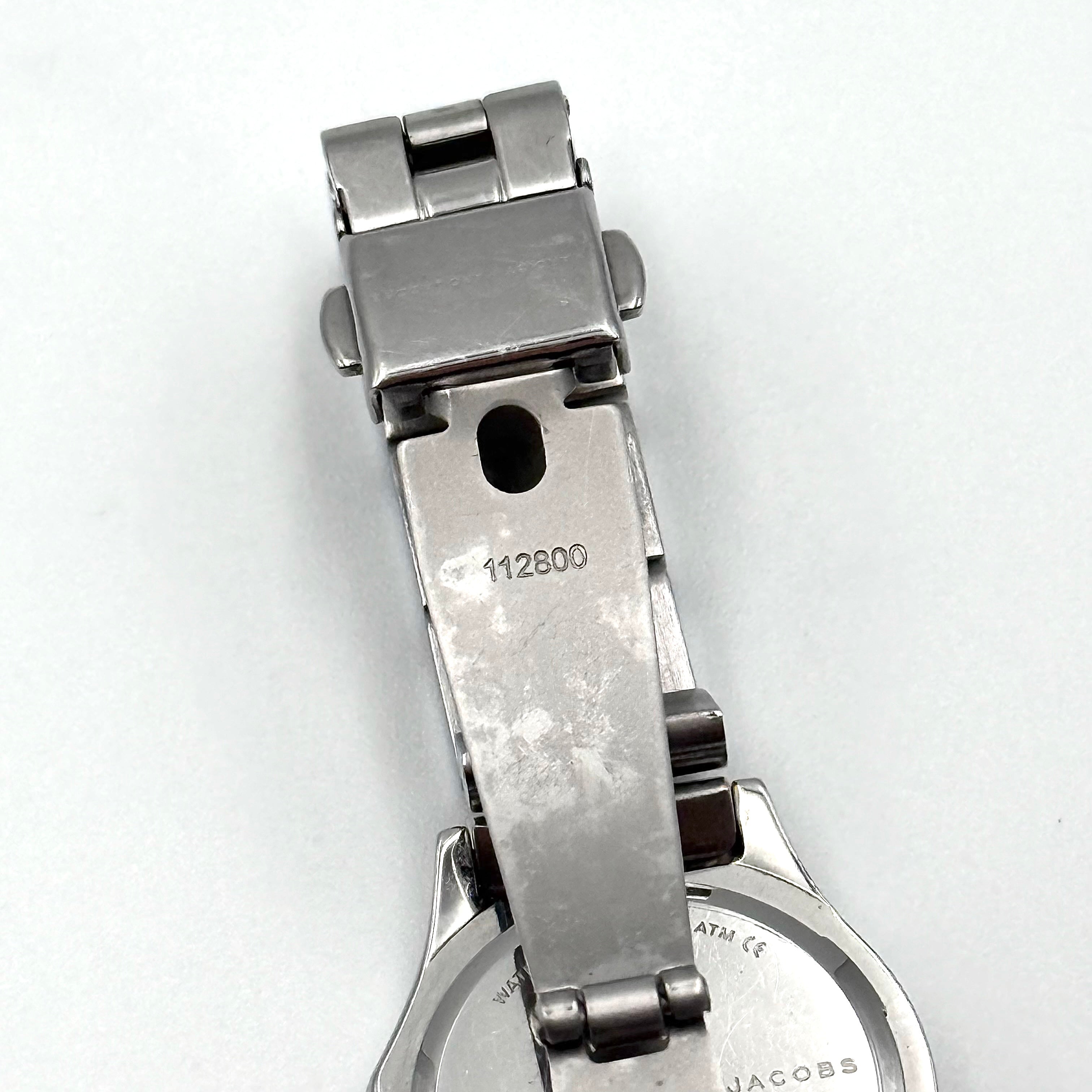 Marc Jacobs Blade MBM3049 watch in stainless steel with a cream bezel, shown on a black cushion.