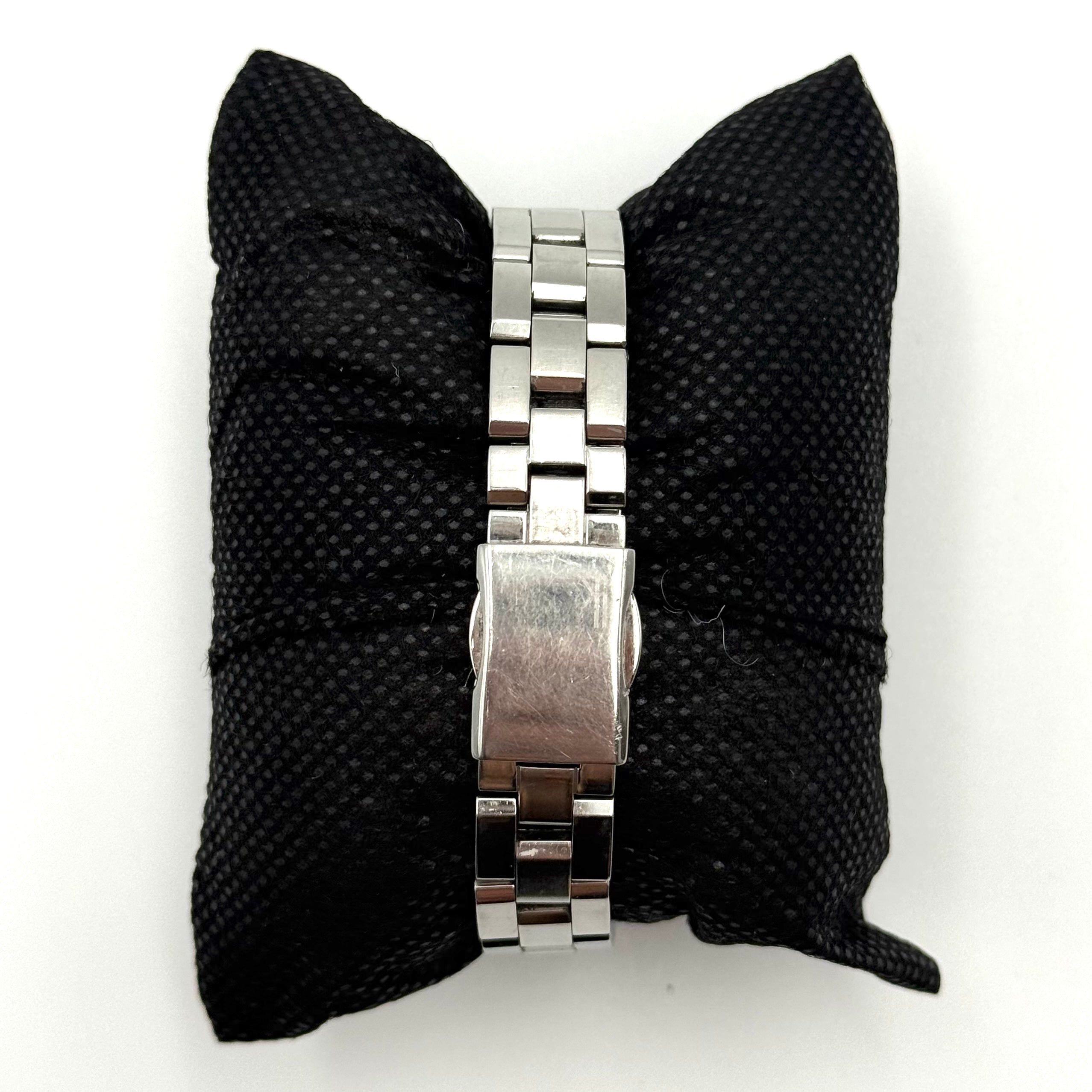 Seiko Lukia stainless steel watch with a rectangular case and silver dial presented on a cushion.