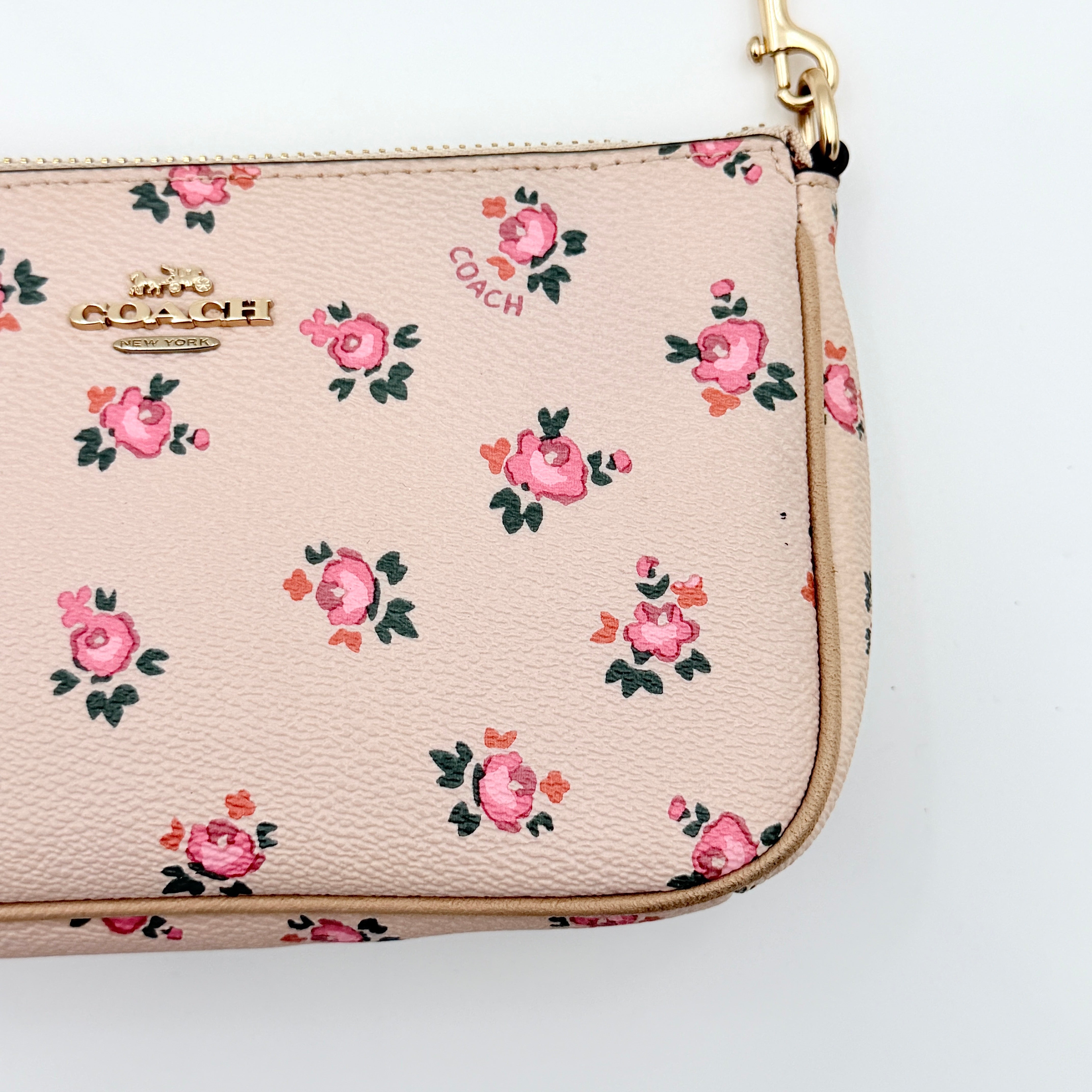 Coach Nolita 19 pink shoulder bag in floral print with gold chain handle, photographed against a white background.