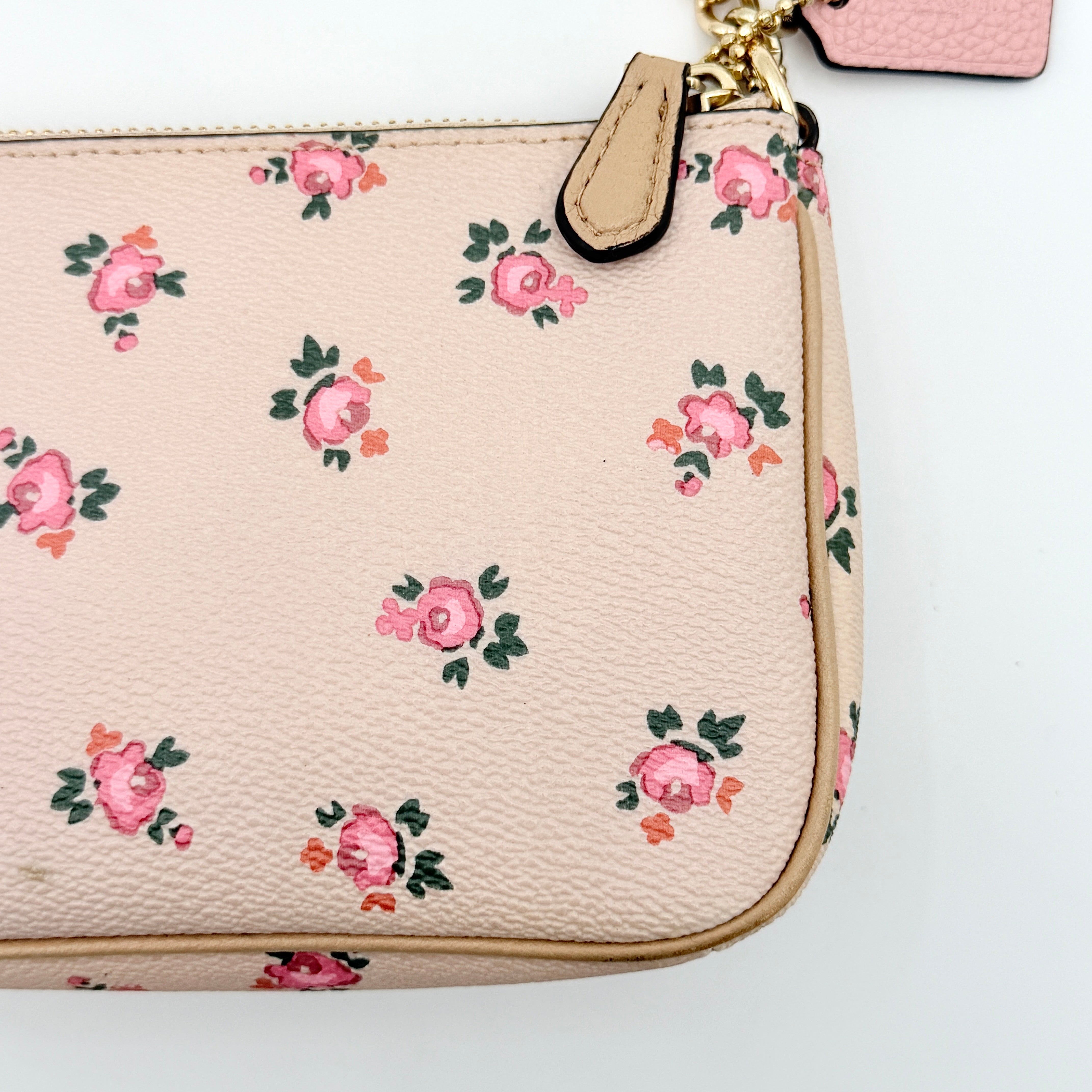 Coach Nolita 19 pink shoulder bag in floral print with gold chain handle, photographed against a white background.