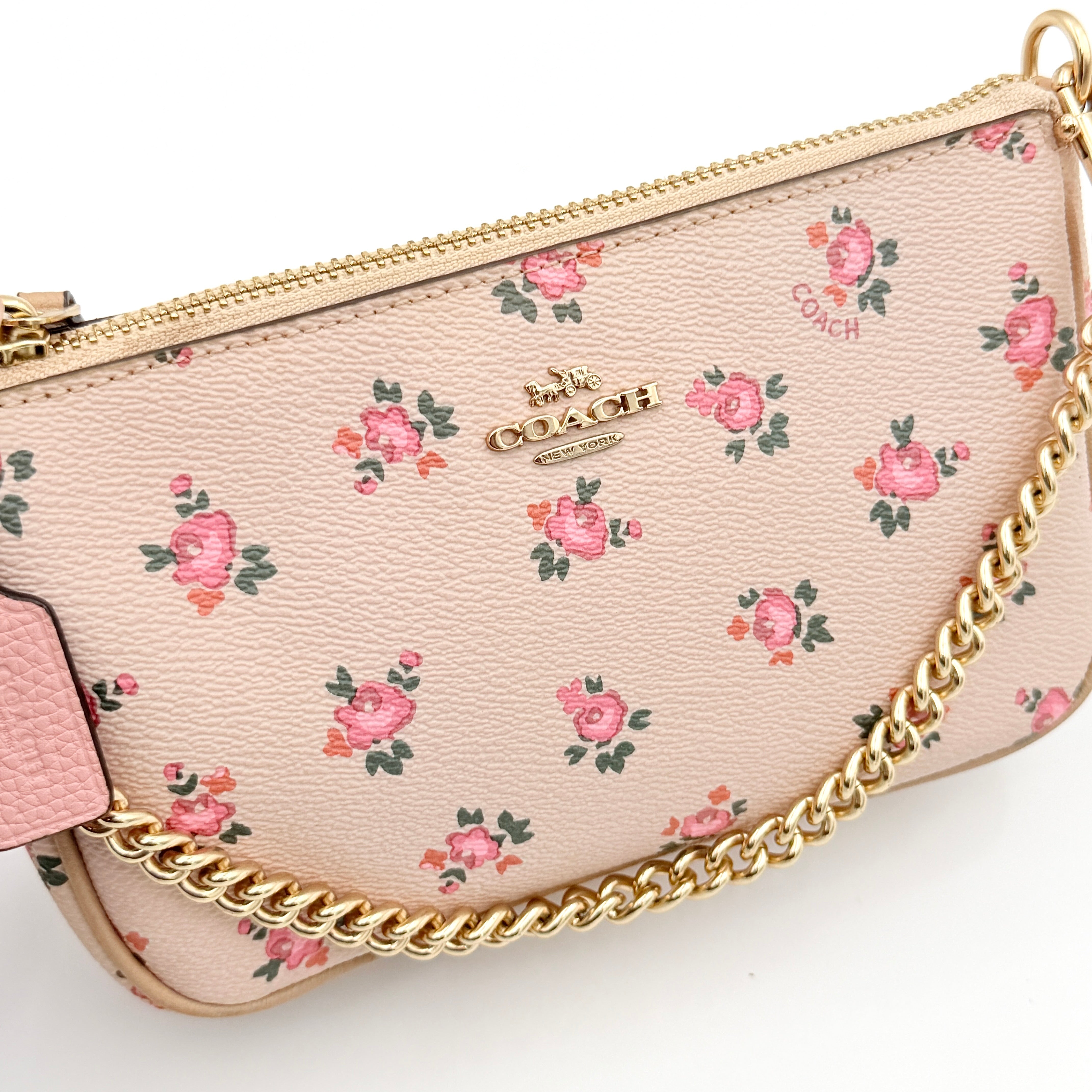Coach Nolita 19 pink shoulder bag in floral print with gold chain handle, photographed against a white background.