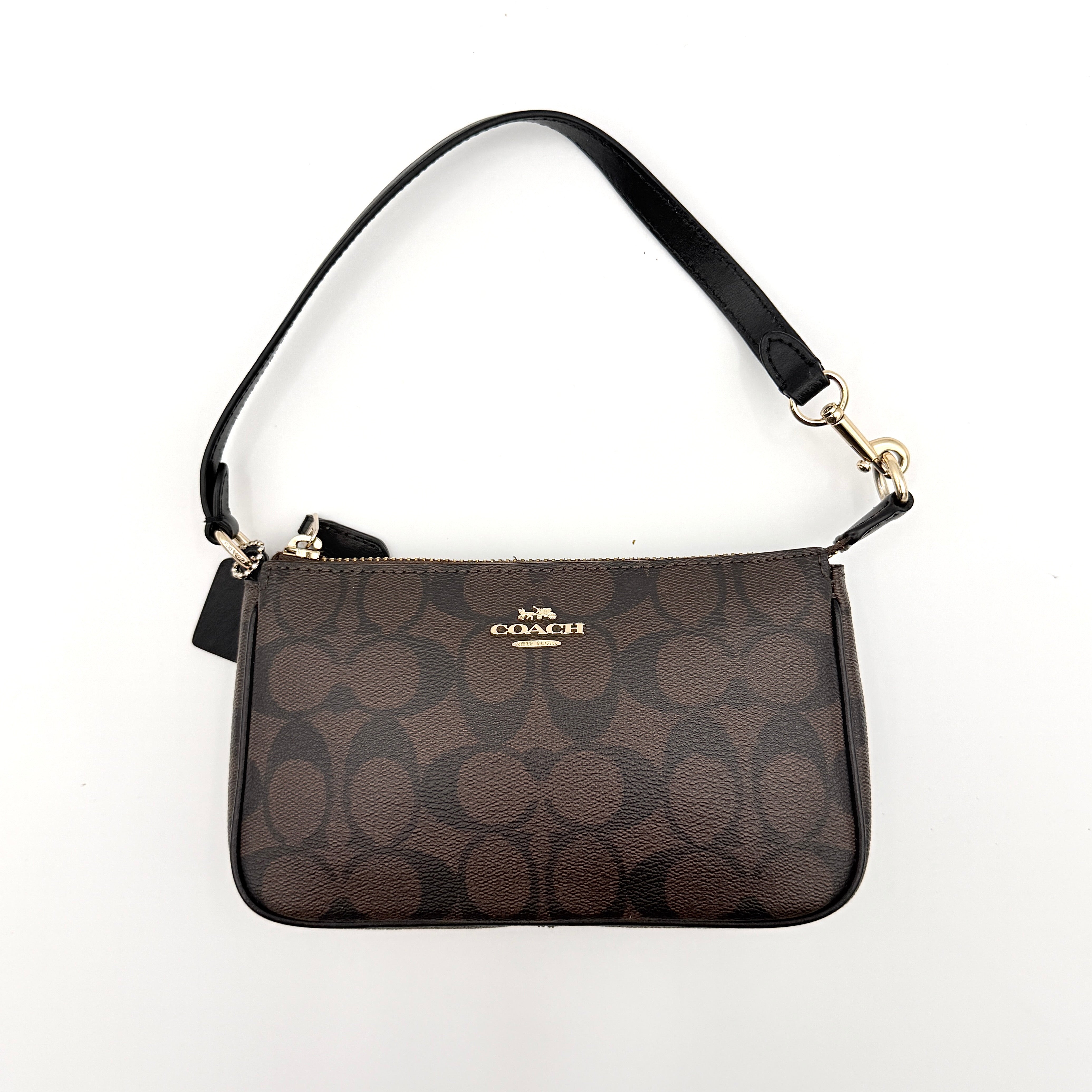 Coach Signature Nolita 19 shoulder bag in brown monogram canvas with black leather strap and gold-tone hardware, shown against a white background.