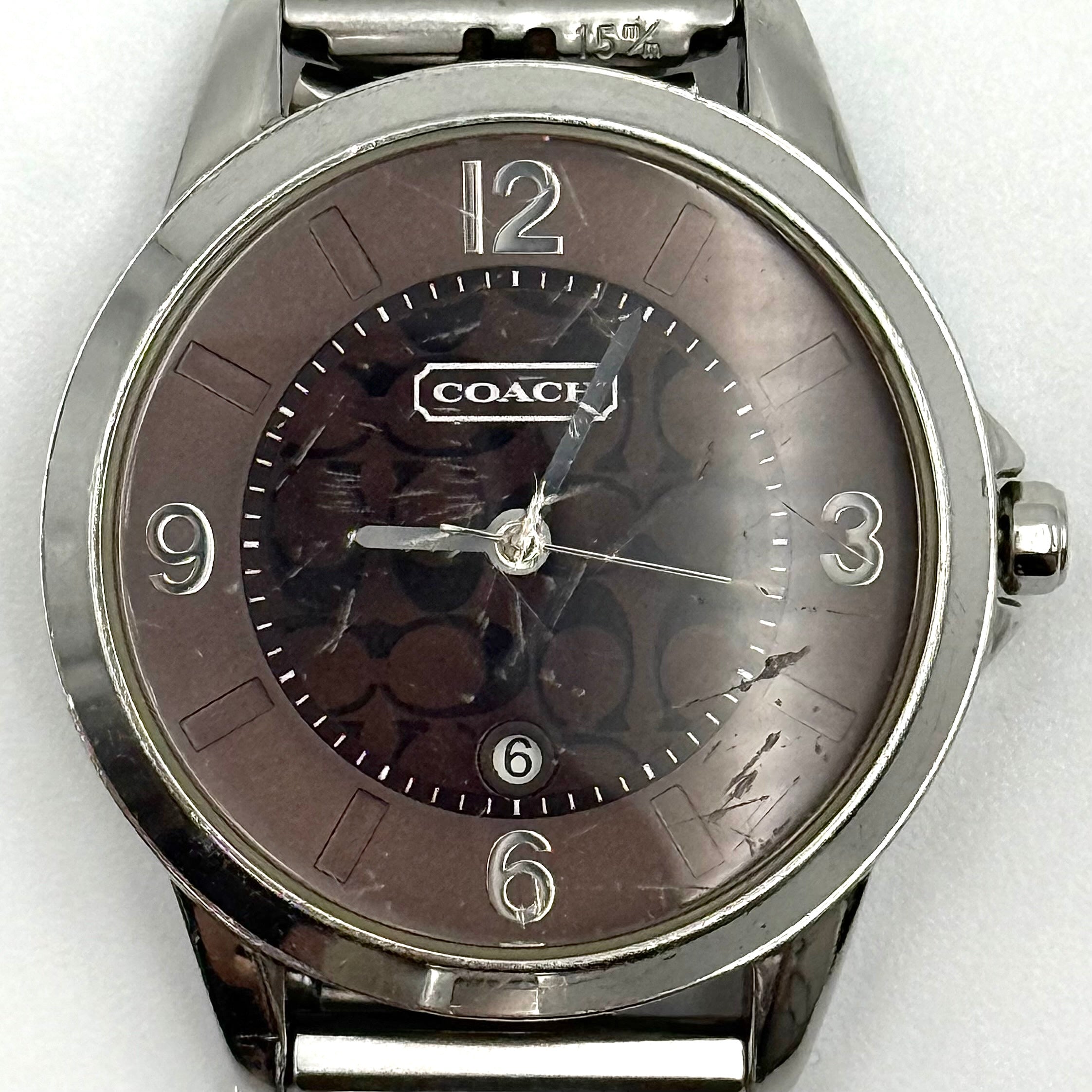Coach CA.13.7.14.0431 stainless steel watch with brown dial and silver-tone bracelet, presented on a black cushion.